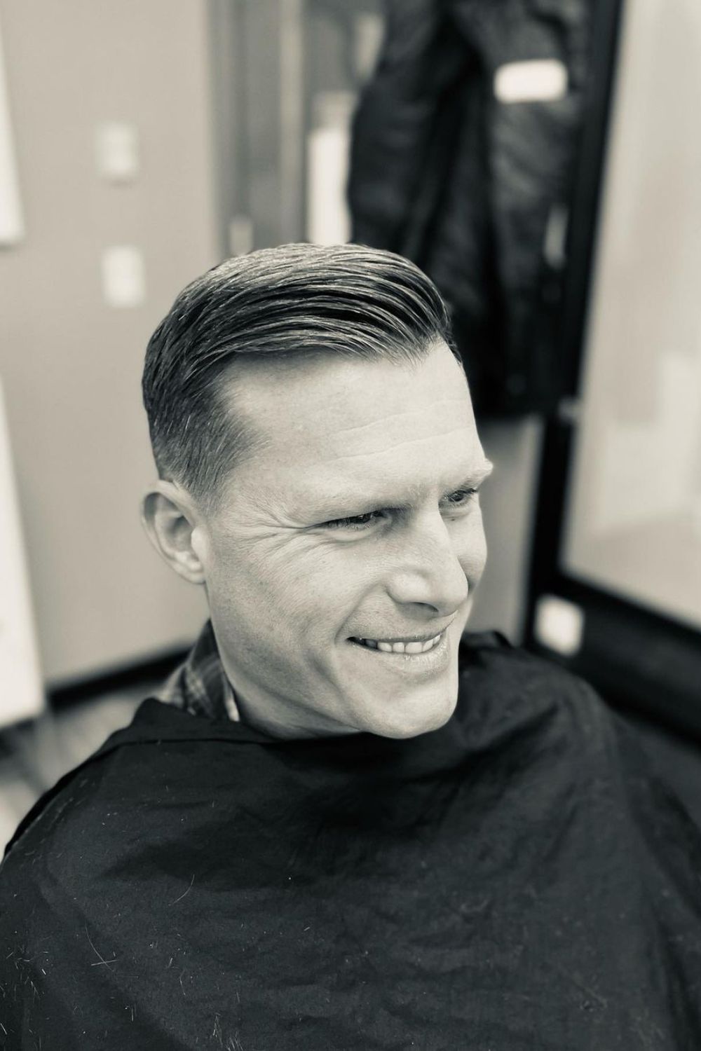 A black and white image of a man with a classic crew cut.