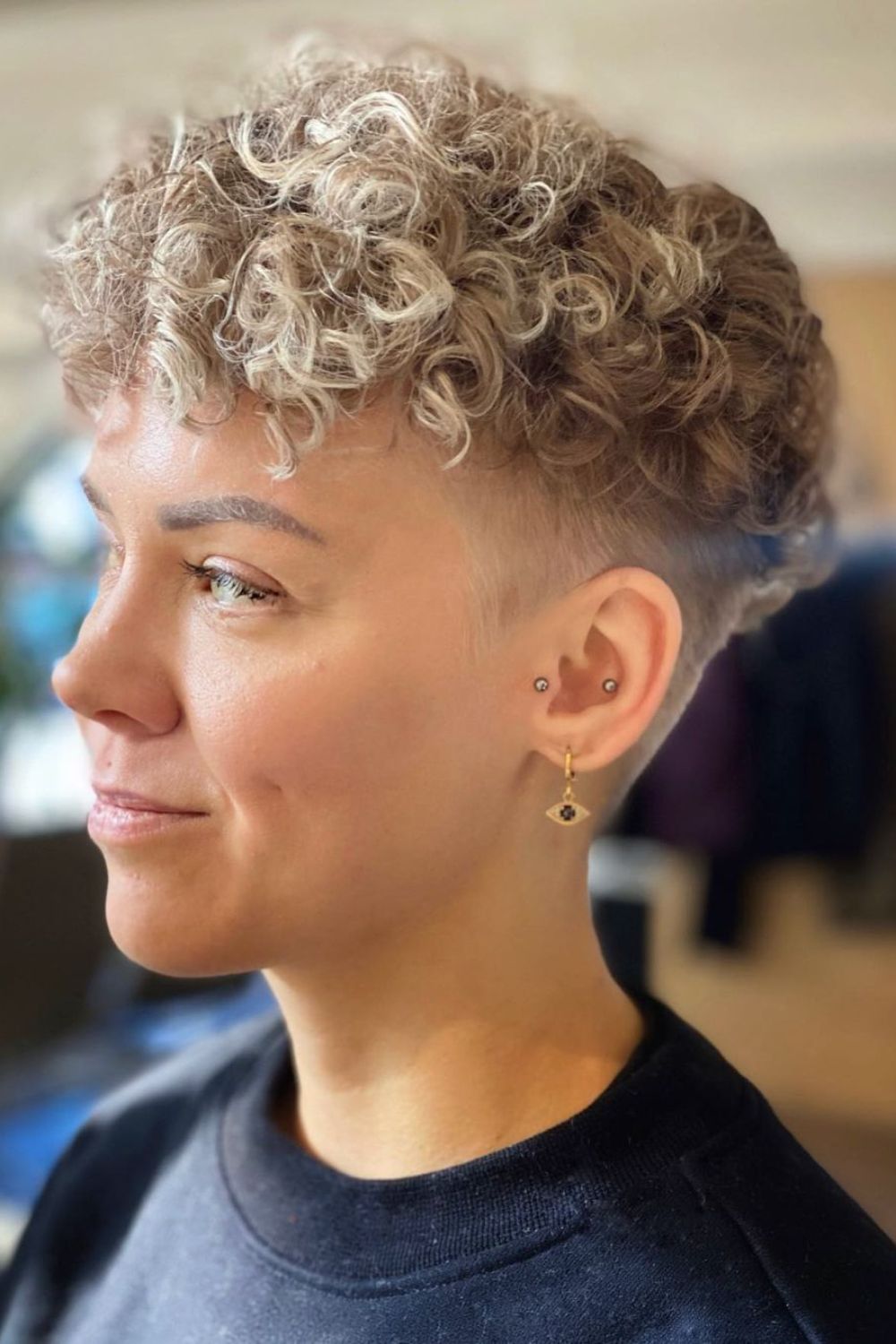 A woman with a blonde curly bowl cut.