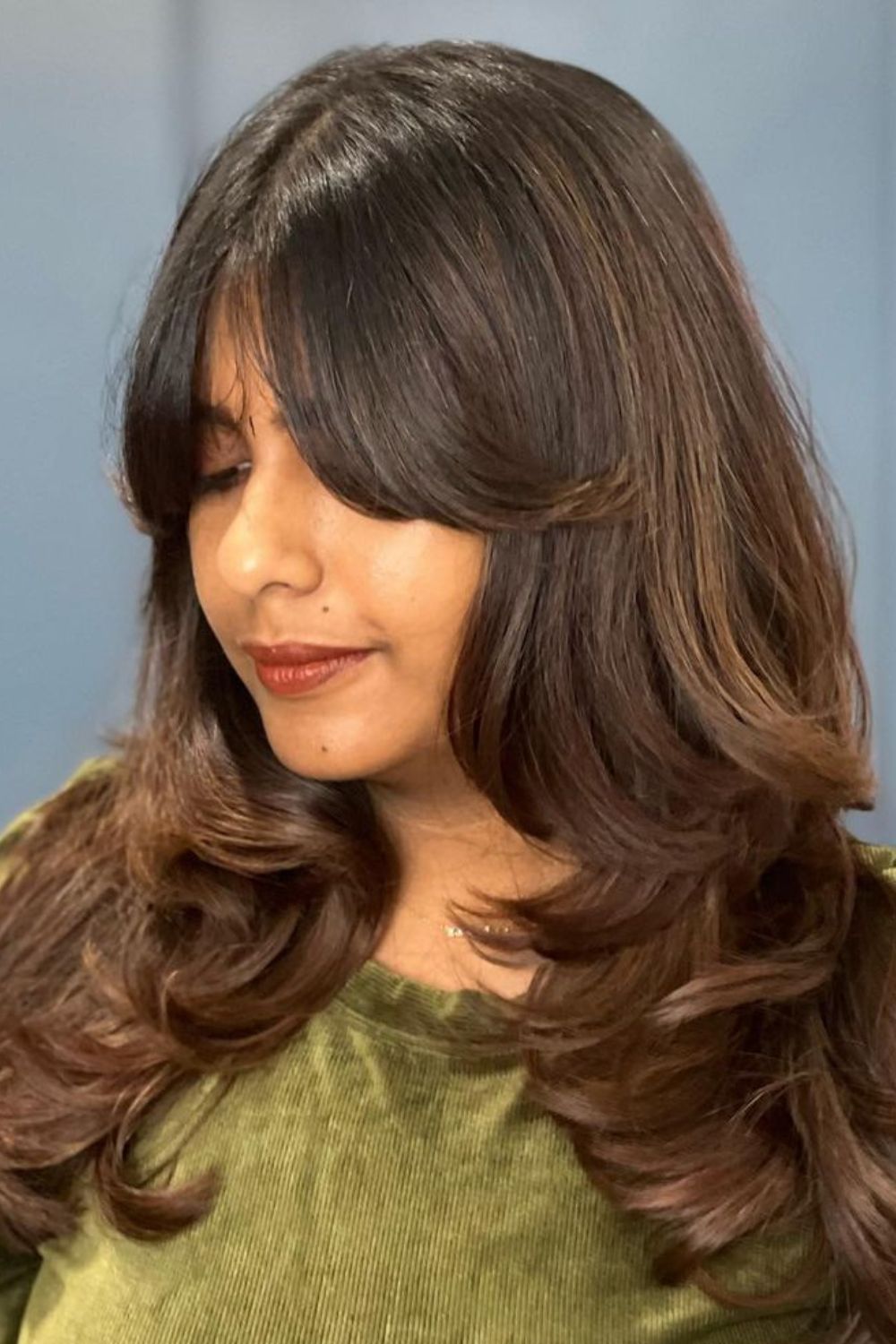 A woman with curtain bangs with step layers.