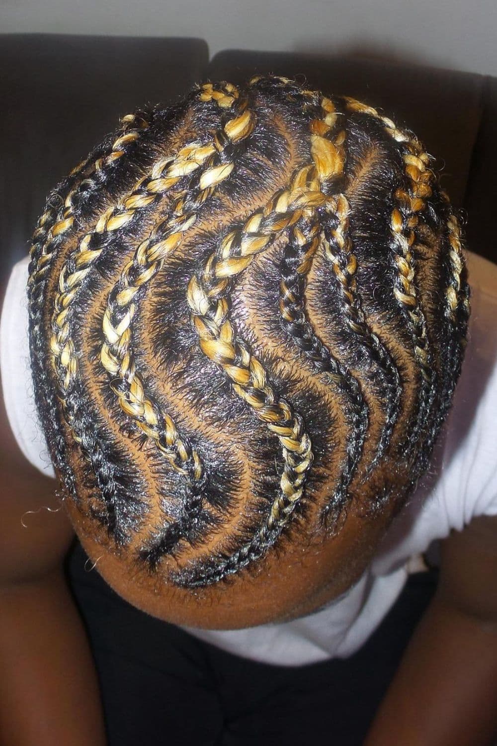 A man with black and blonde curved cornrows.