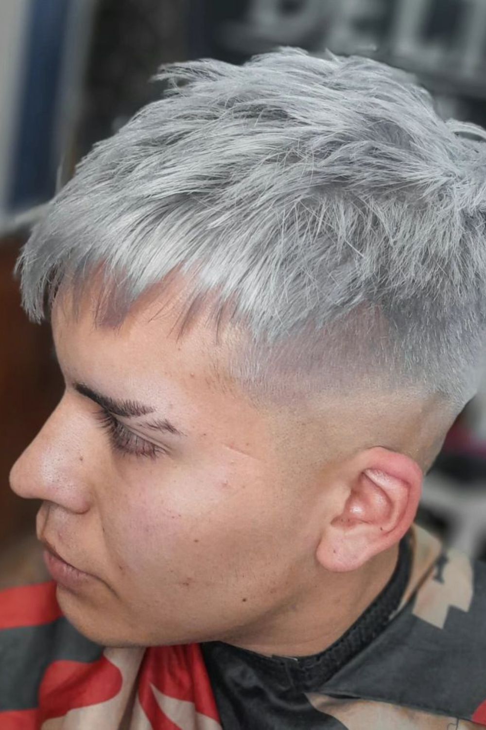 A man with a silver drop fade French crop.