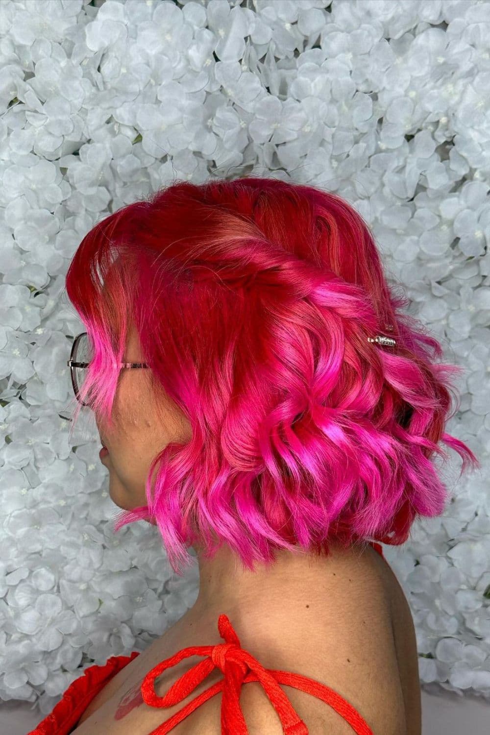 A woman with short pink half up side twists.