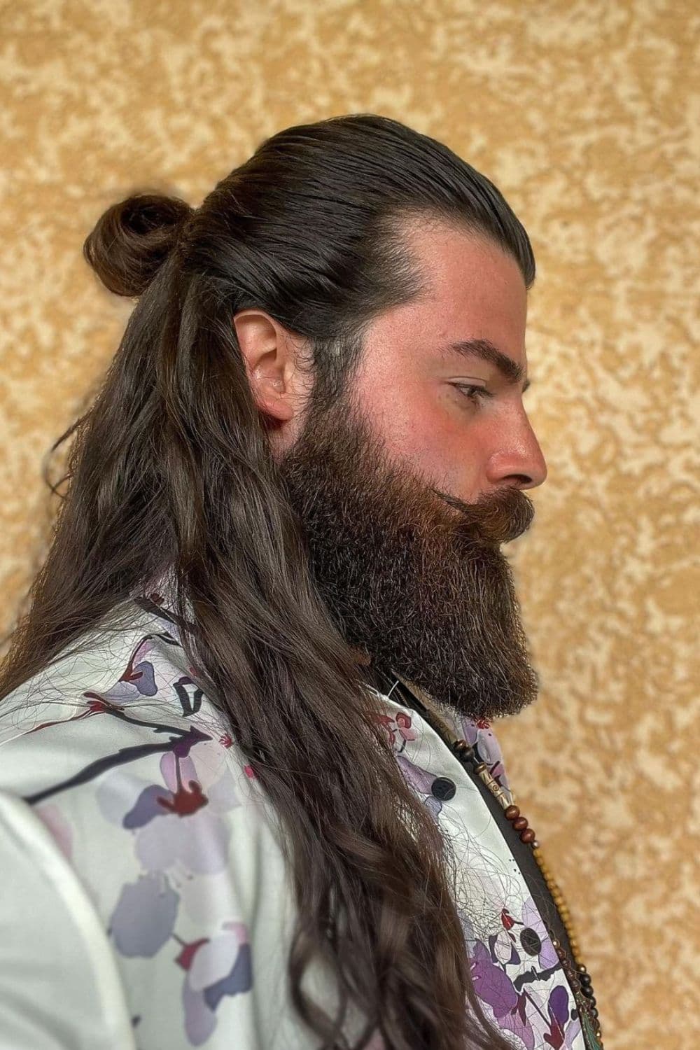 A man with long half-up hairstyle with beards.