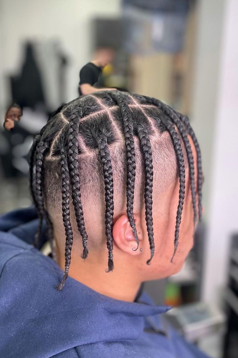 A man with a high fade mid-length box braids.