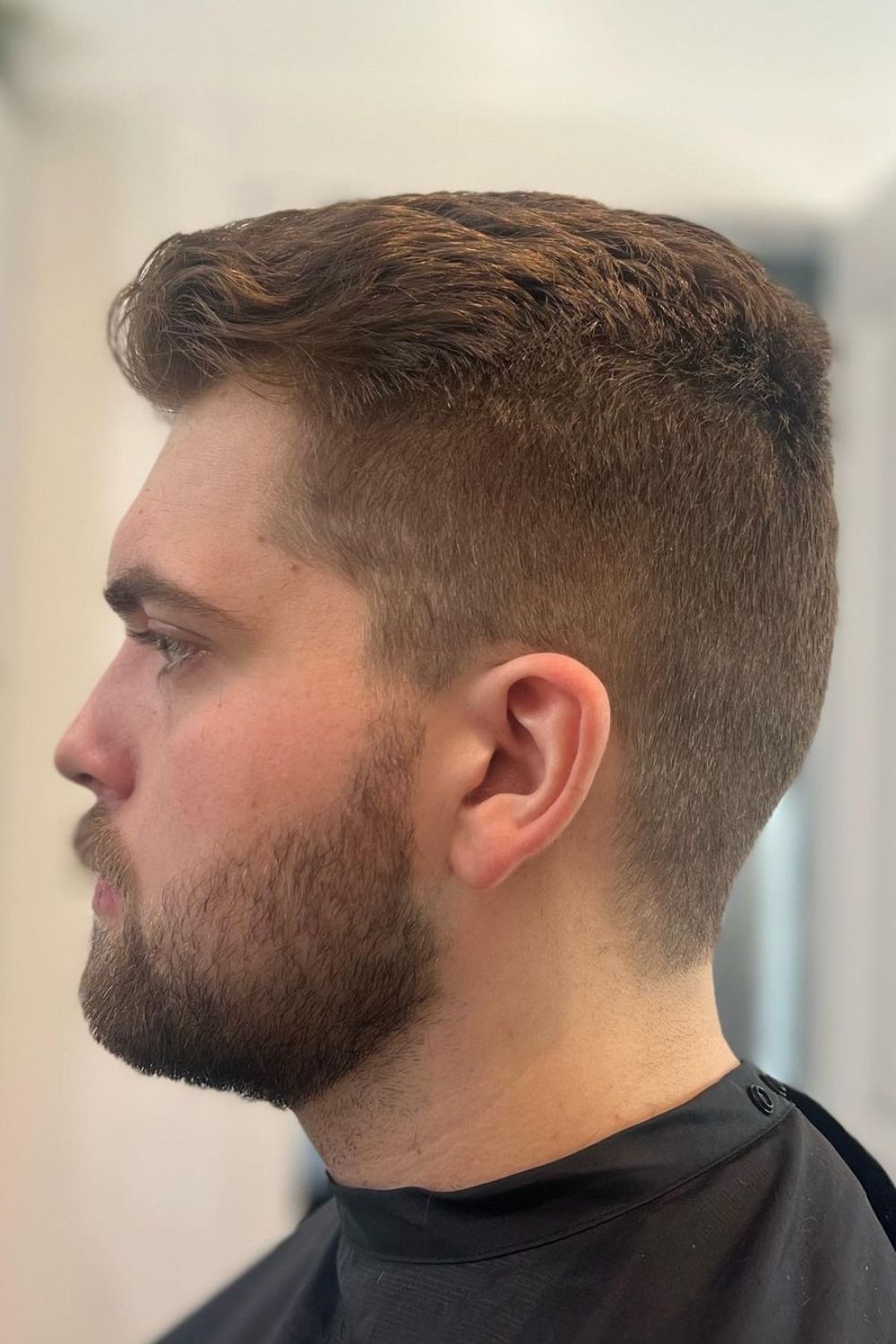 A man with a layered crew haircut.