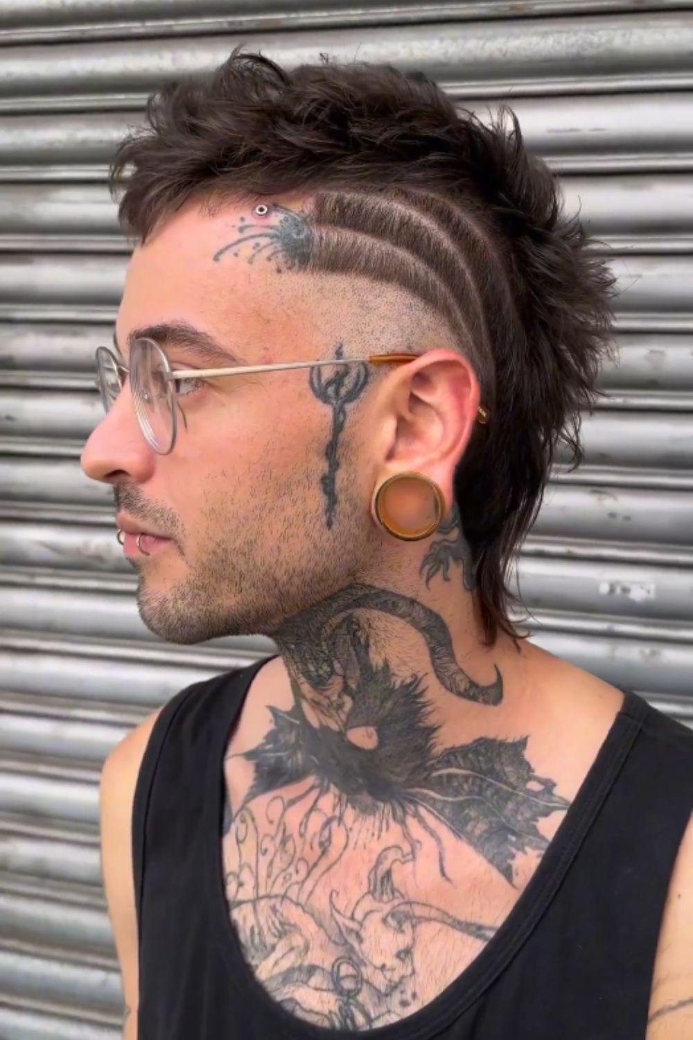 A man with a layered faux hawk with a disconnected skin fade.
