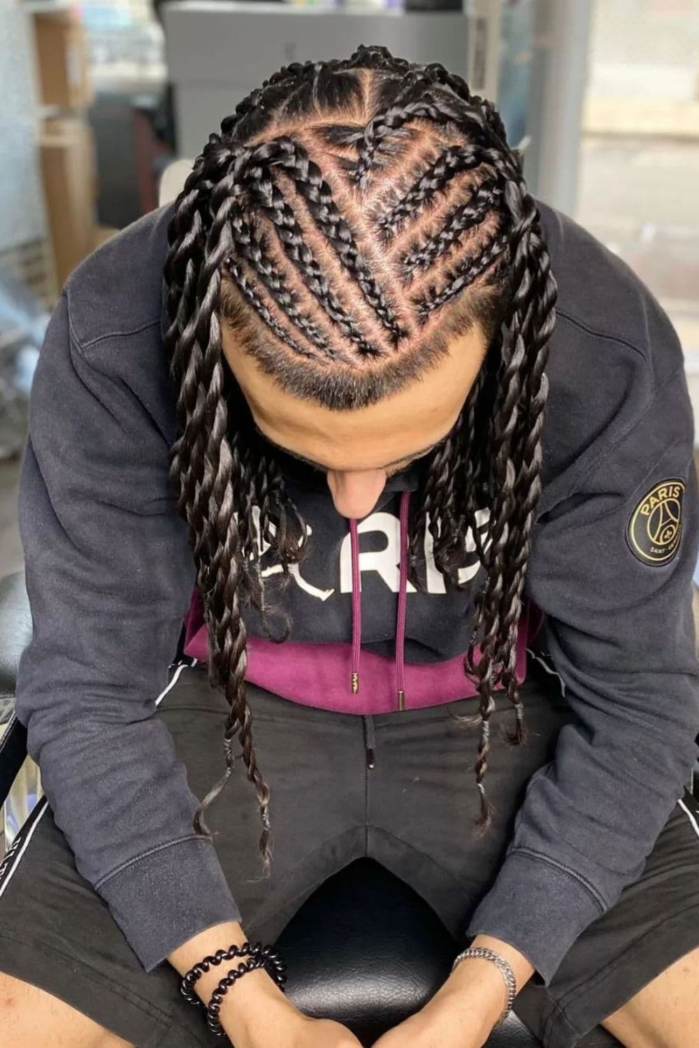 A man with cornrows into long twists.