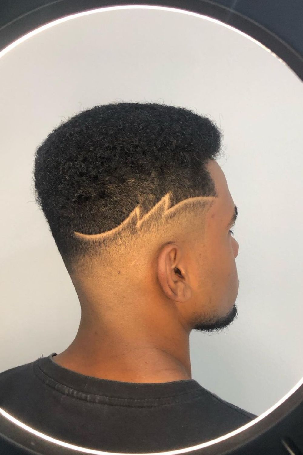 A man with a mid fade Afro cut.