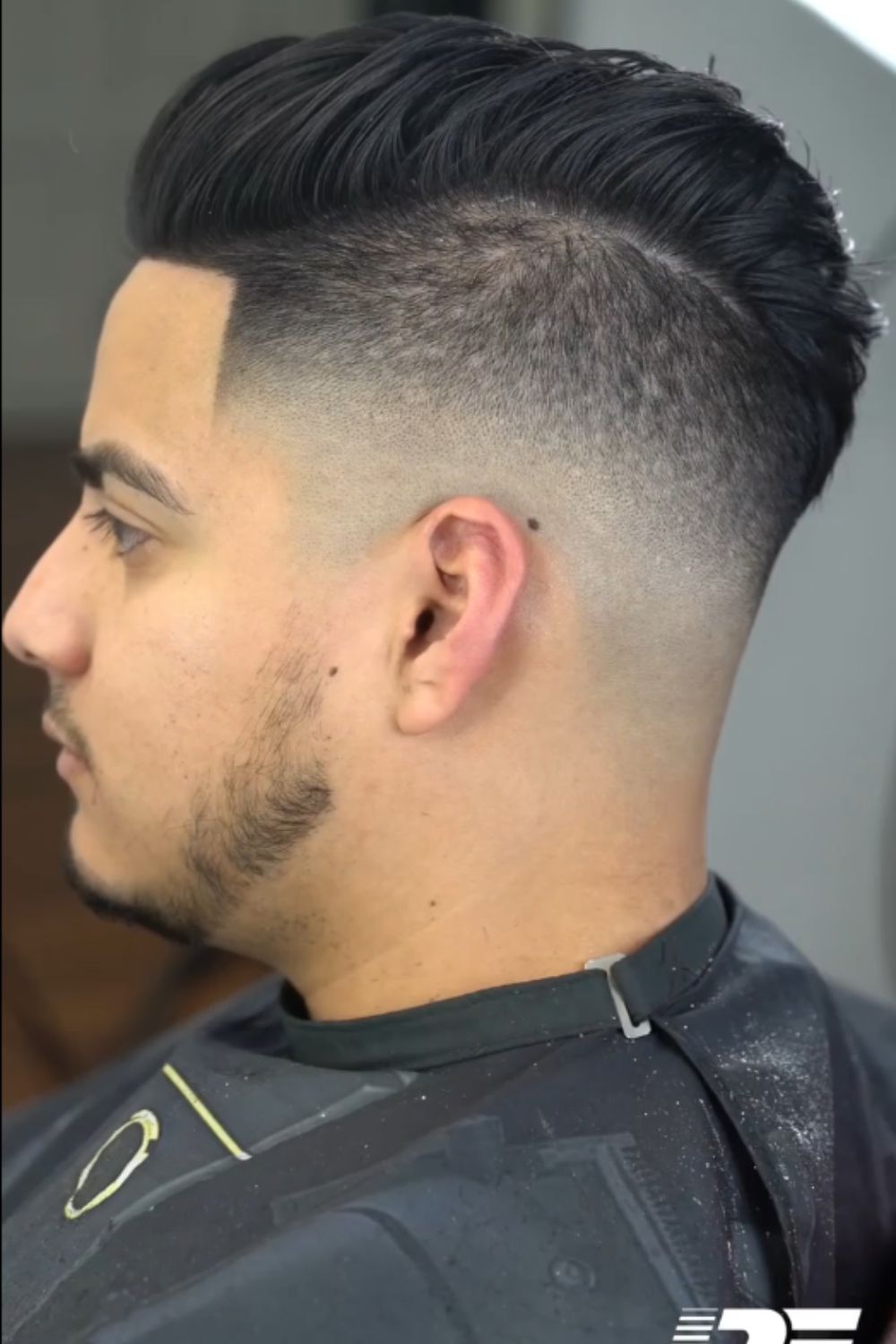 A man with a mid fade brush up.
