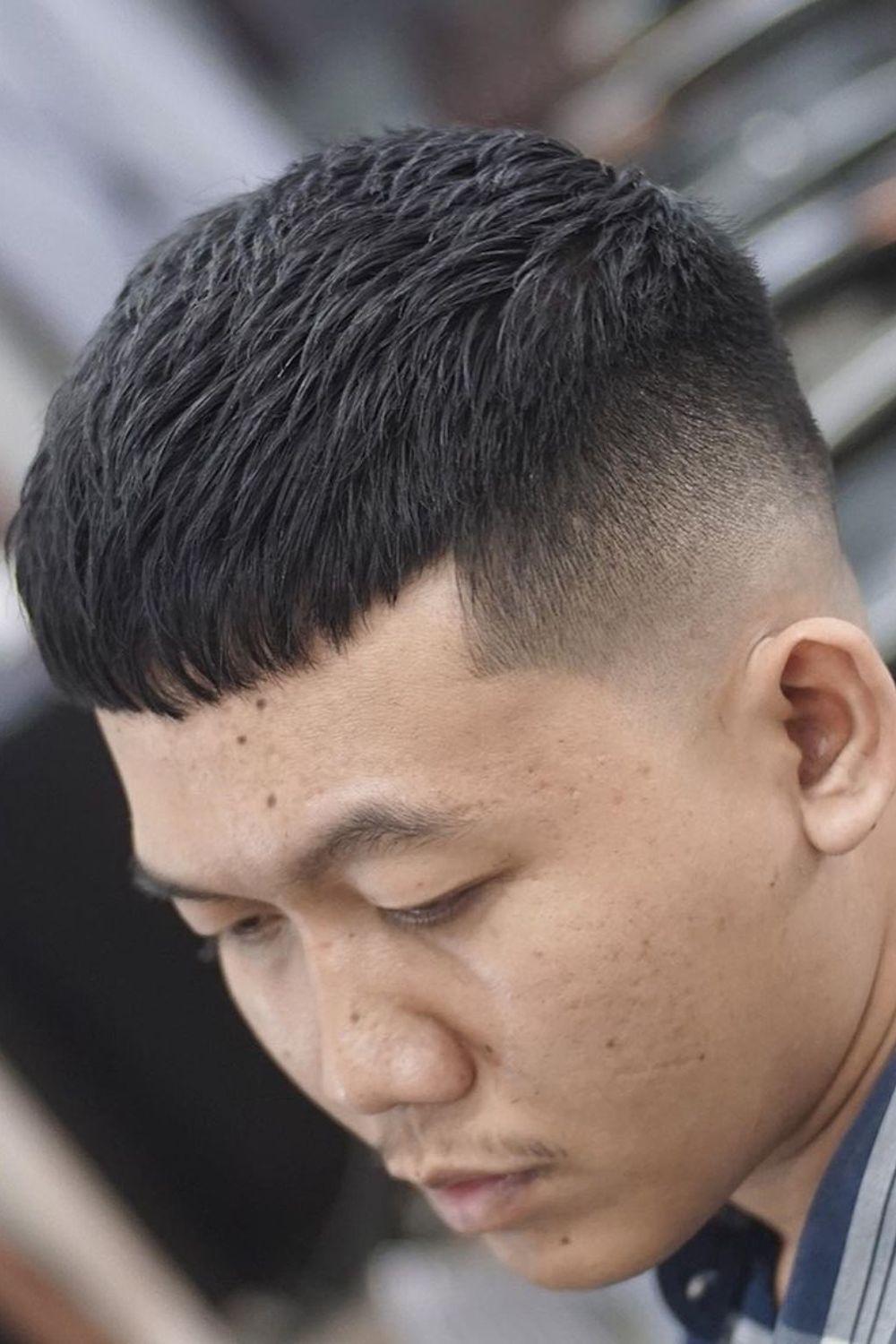 A man with a mid-fade French crop.
