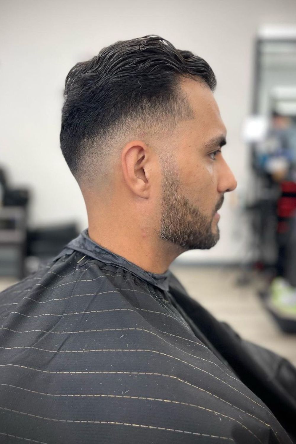 A man with a mid fade slick back.