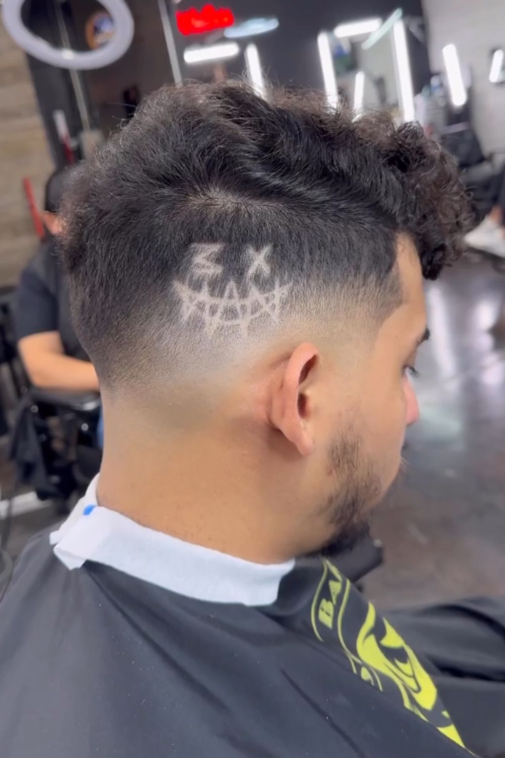 A man with a mid fade cut with design.