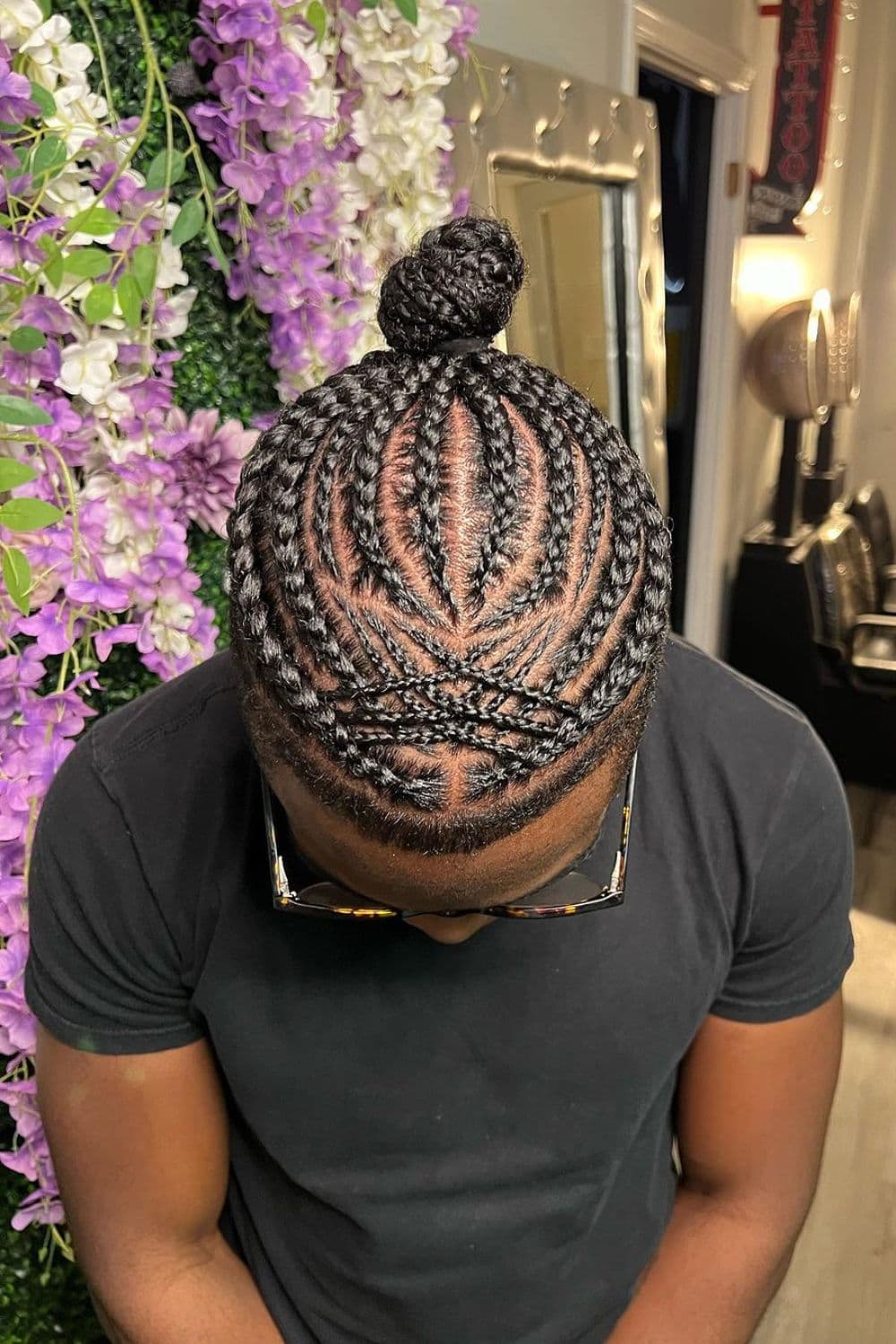 A man with mixed-size cornrows.
