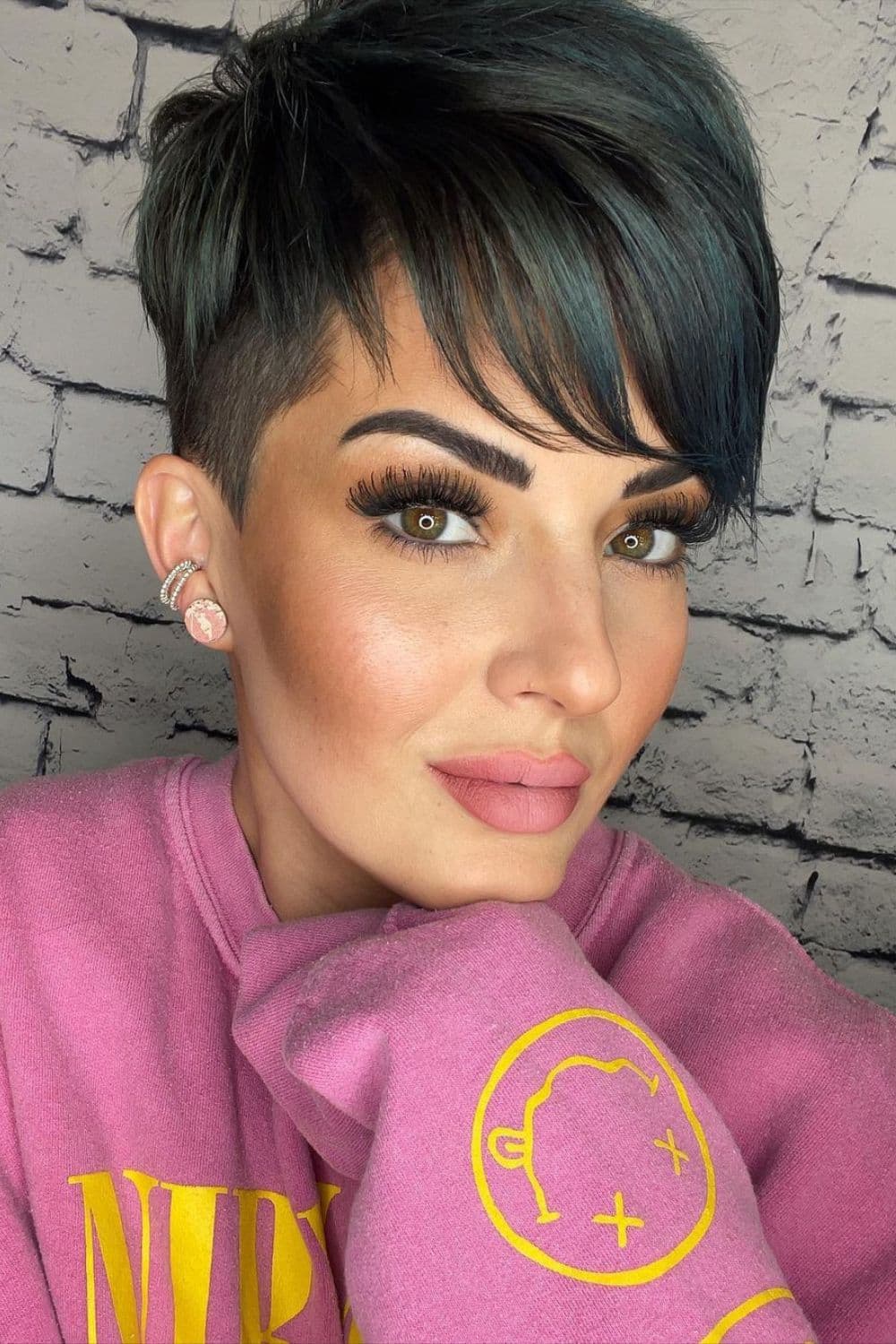 A woman with a pixie cut with side-swept bangs.