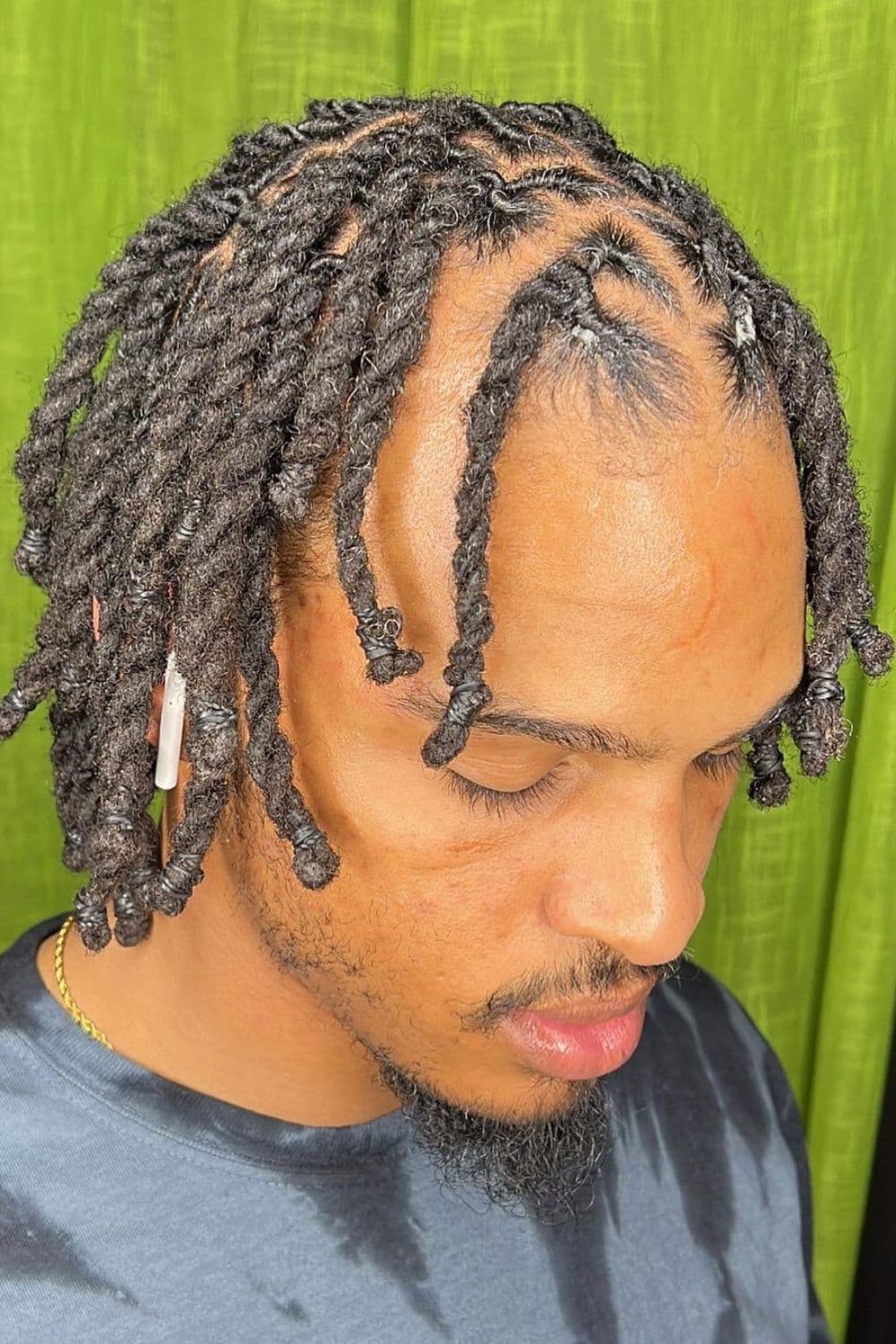 A man with short side-parted twists.