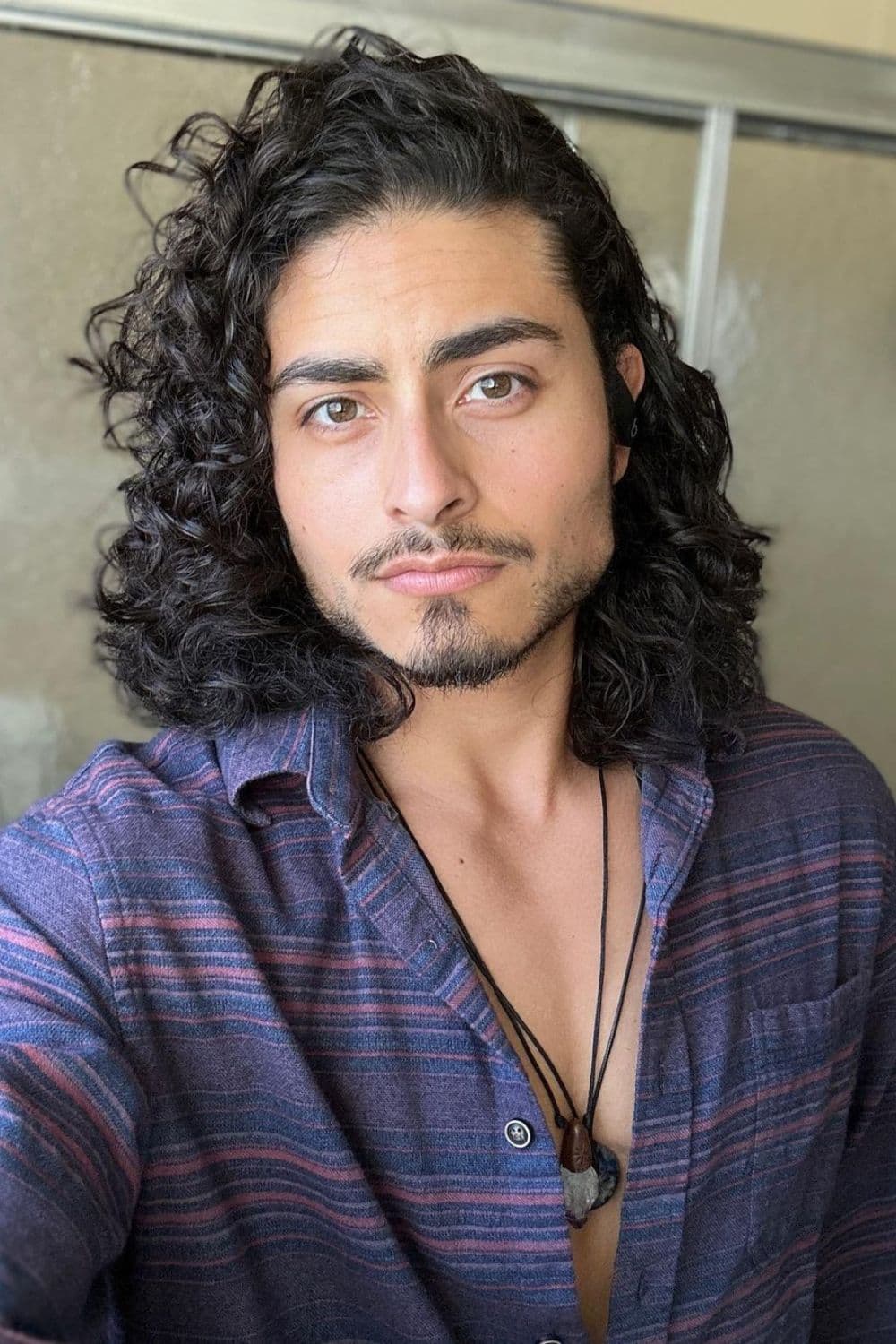 A man with a shoulder-length curly hair.