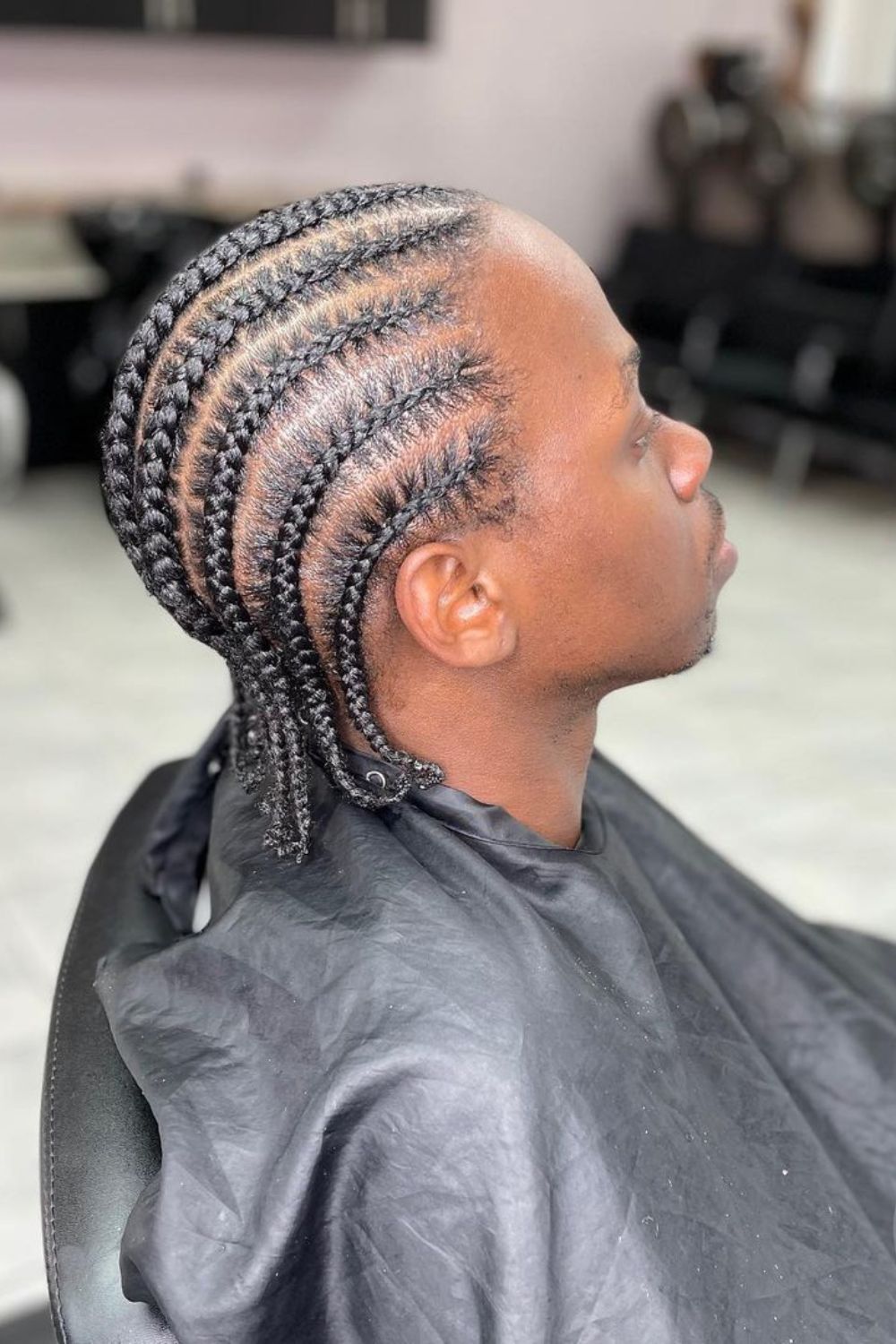 A man with small cornrows.