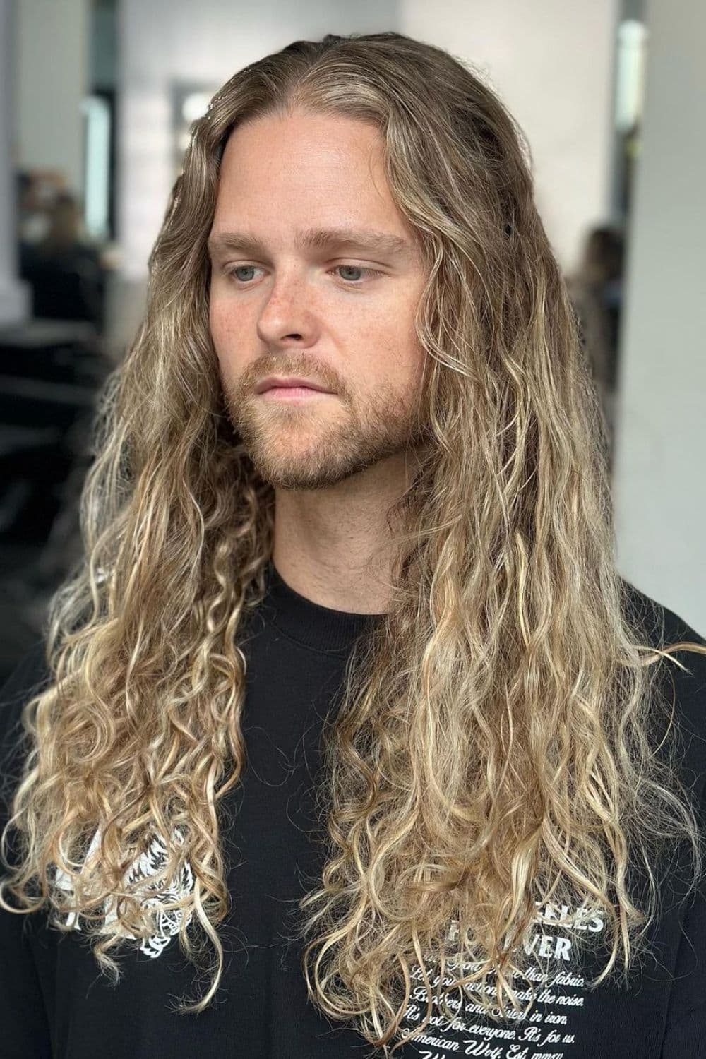 A man with a long blonde curly hair.