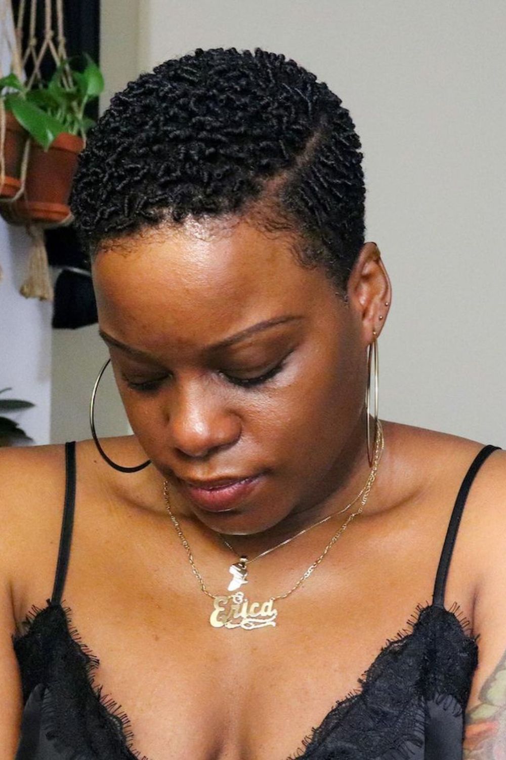 A black woman with a tapered TWA with a side part.