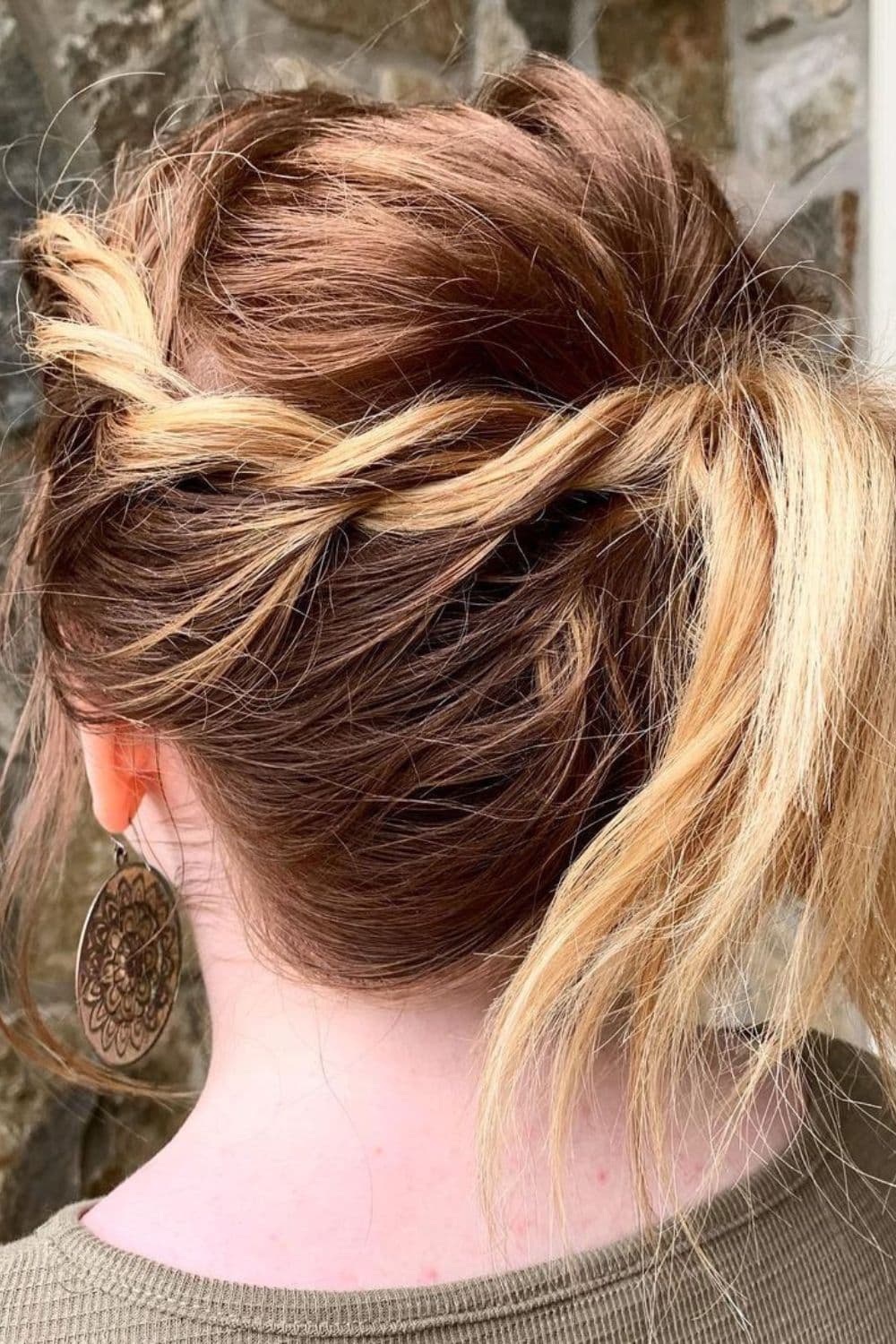 A woman with brown and blonde twisted half ponytail.