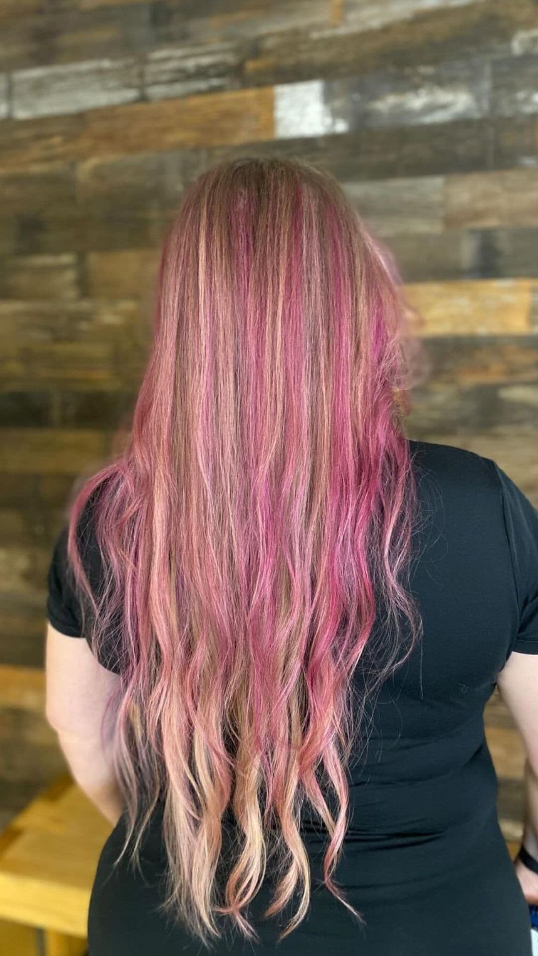 A woman with long hair and pink highlights.