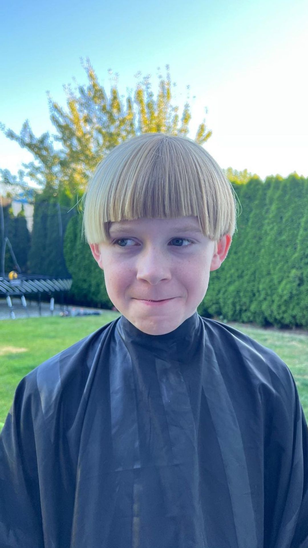 A boy with a blonde bowl cut.