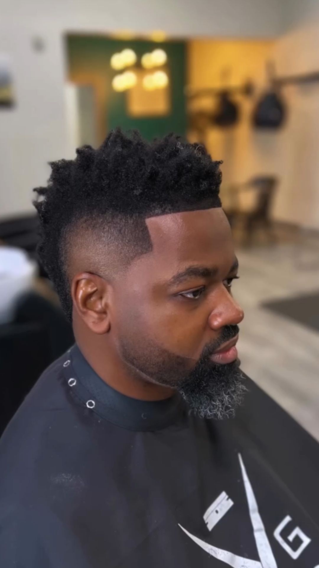 A man with a burst fade Afro haircut.