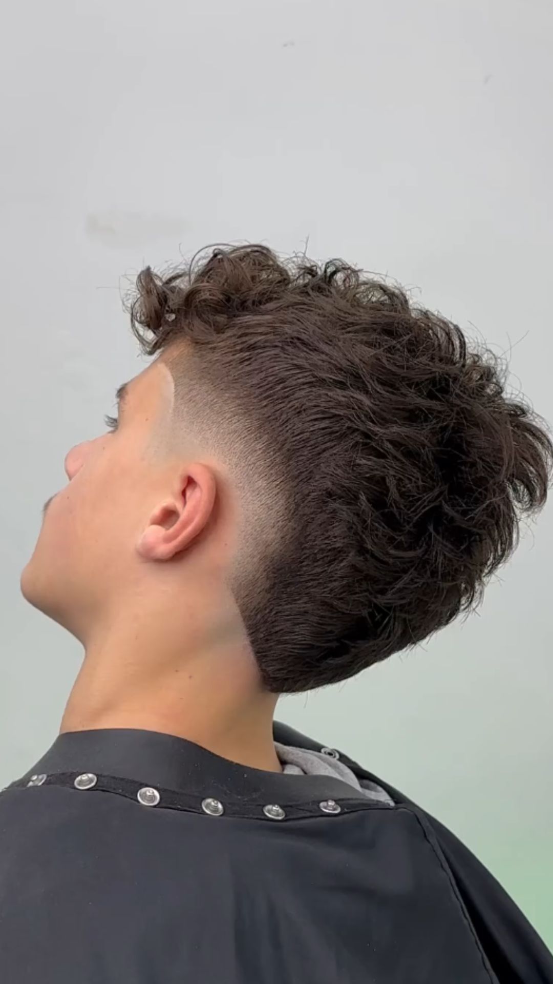 A man with a burst fade and textured waves.