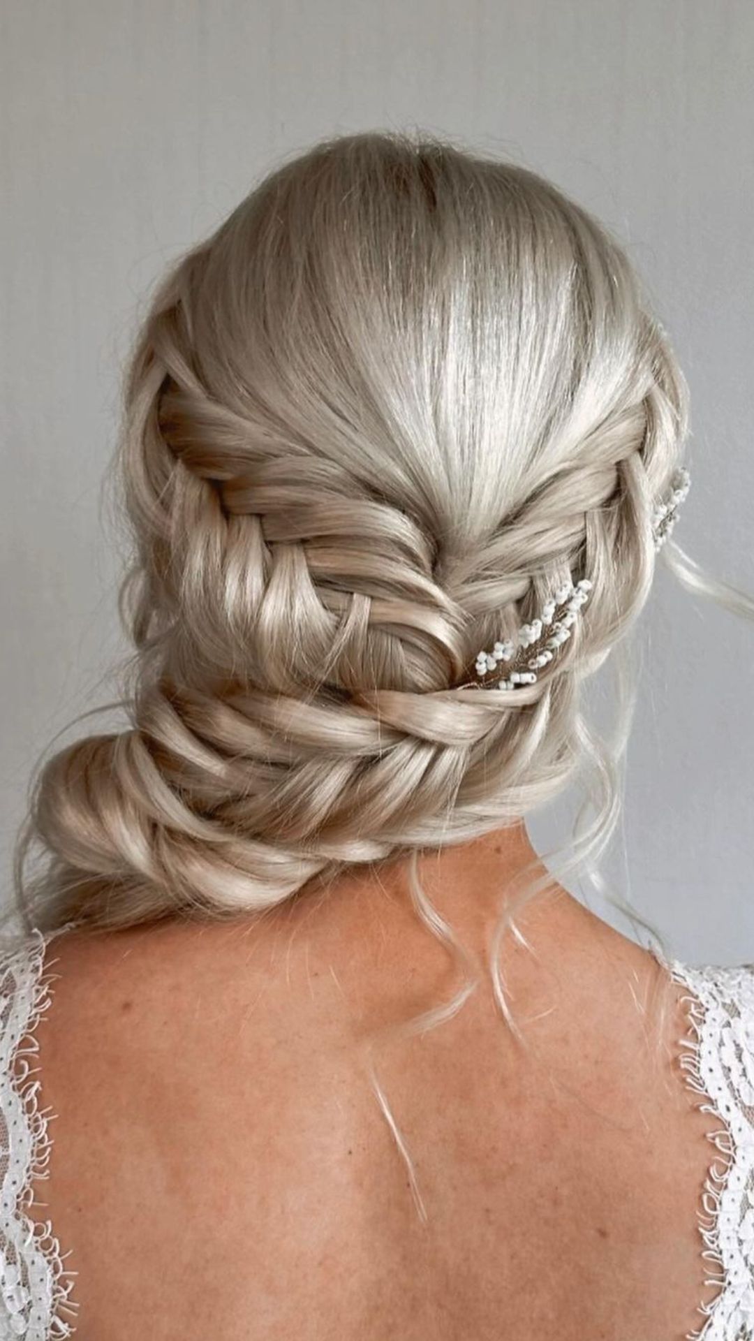A woman with a platinum blonde fun fishtail braid.