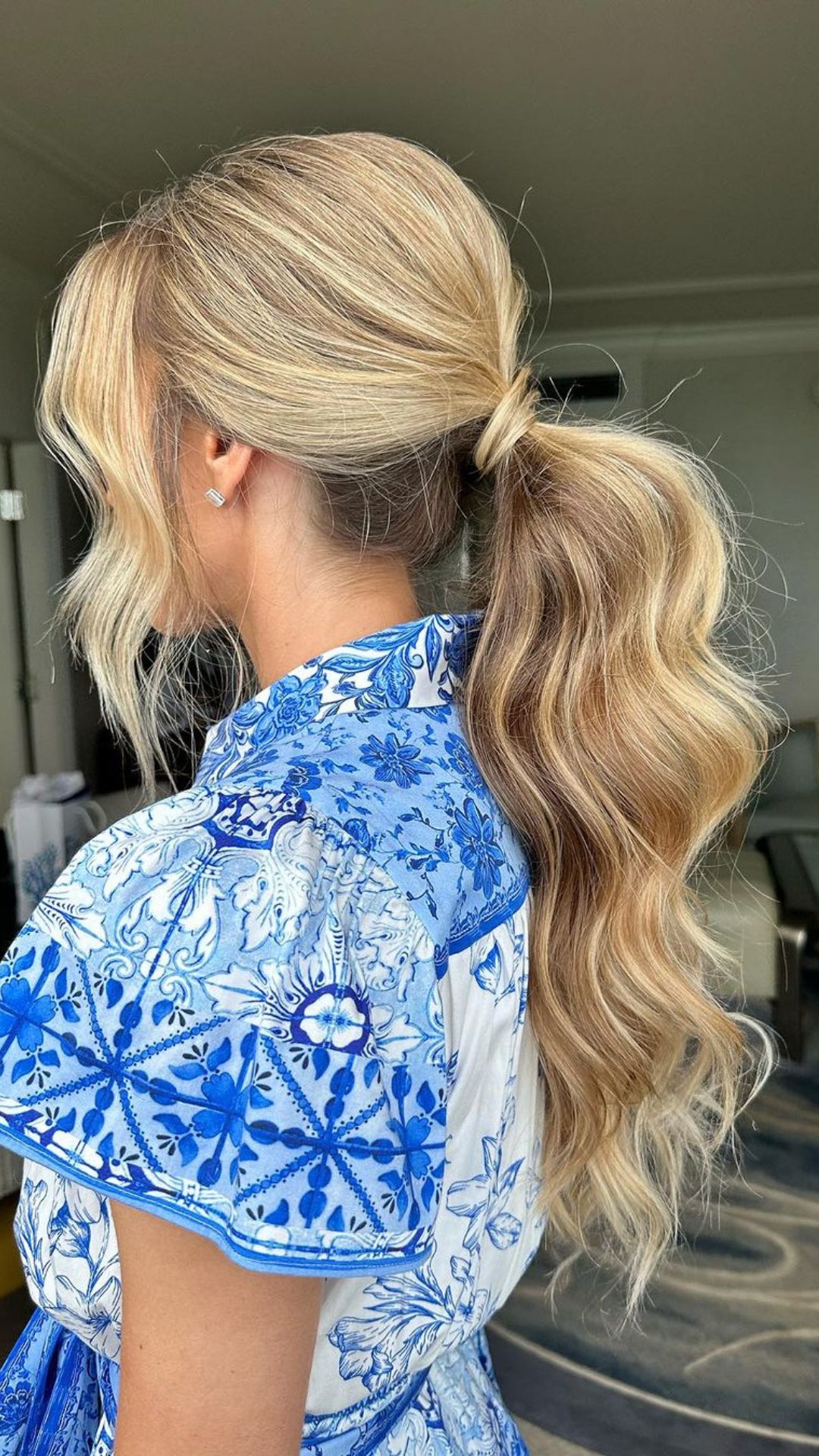 A woman with long blonde low ponytail.