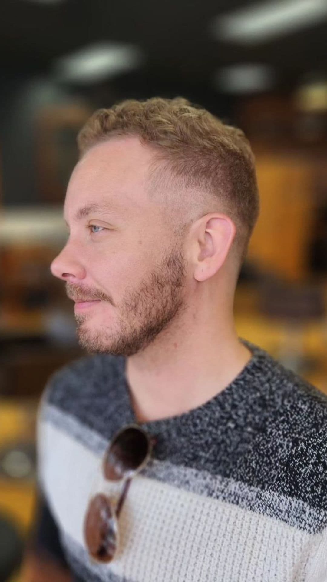 A man with a short curly fade hairstyle.