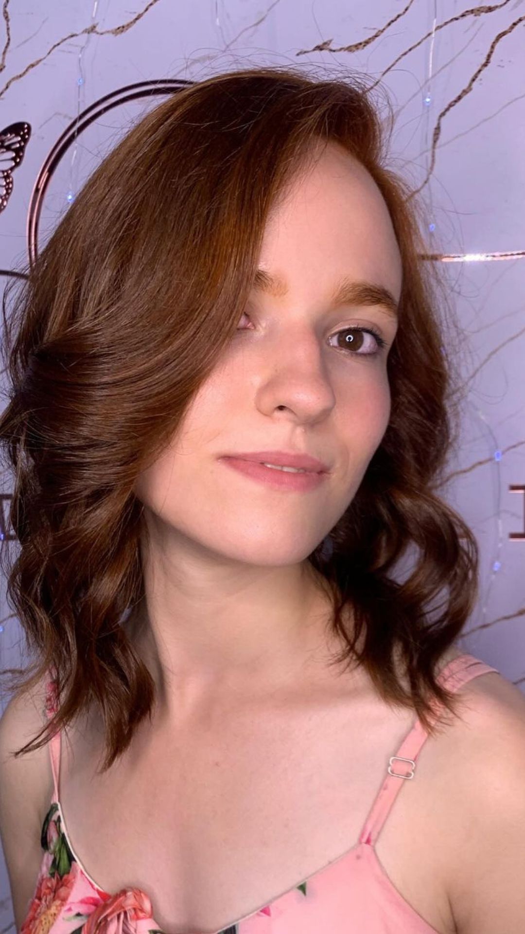 A woman with a side parted wavy lob.