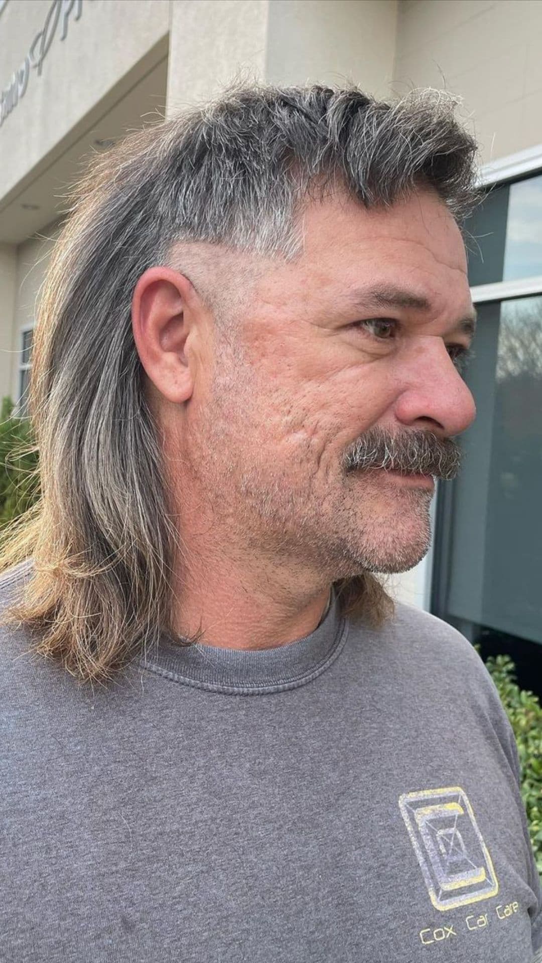 An old man with a gray surfer mullet.