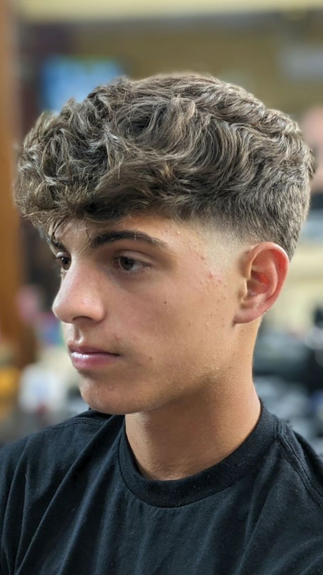 A man with a temple fade and textured fringe.