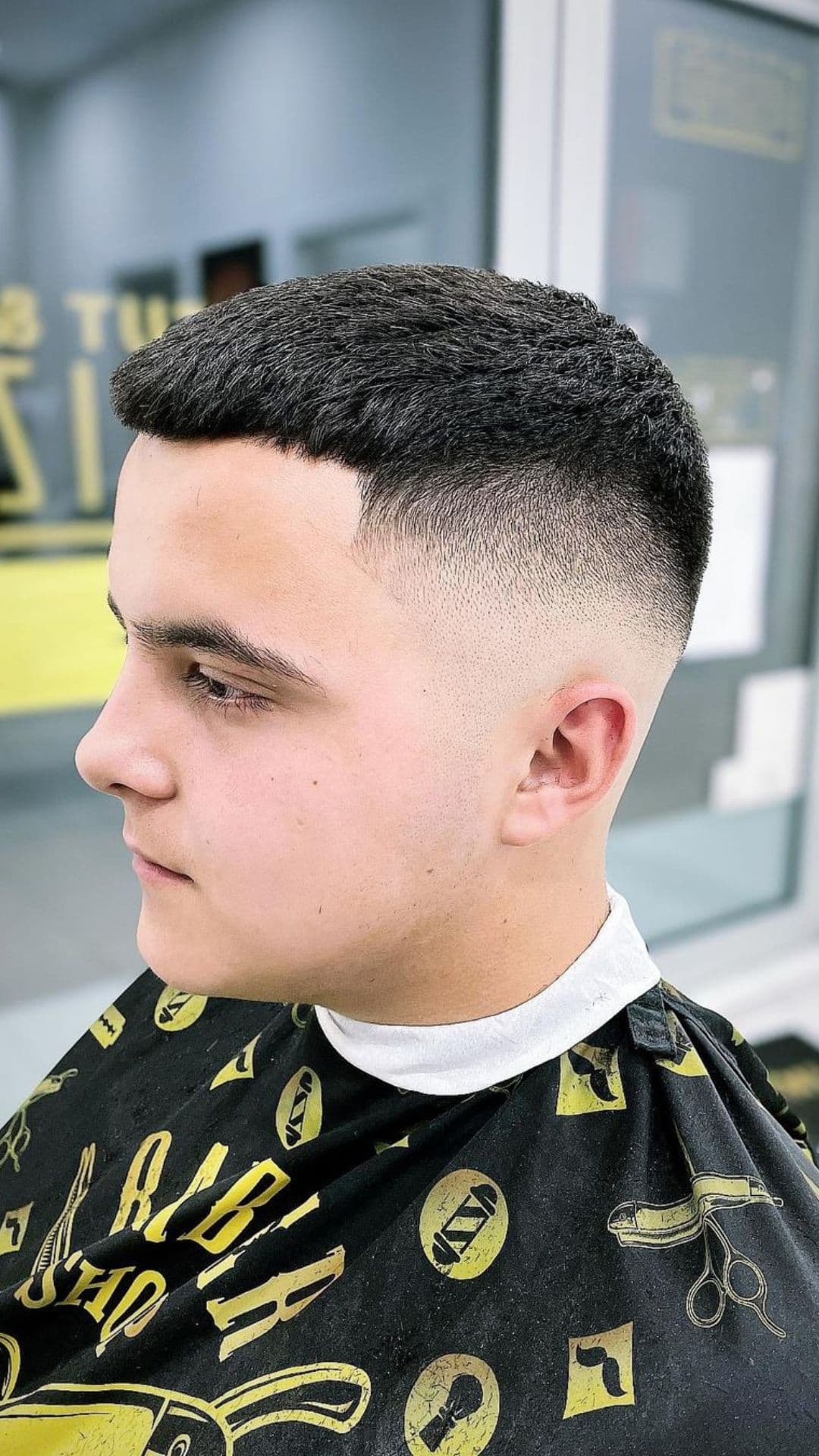 A man with a French crop and skin fade haircut.