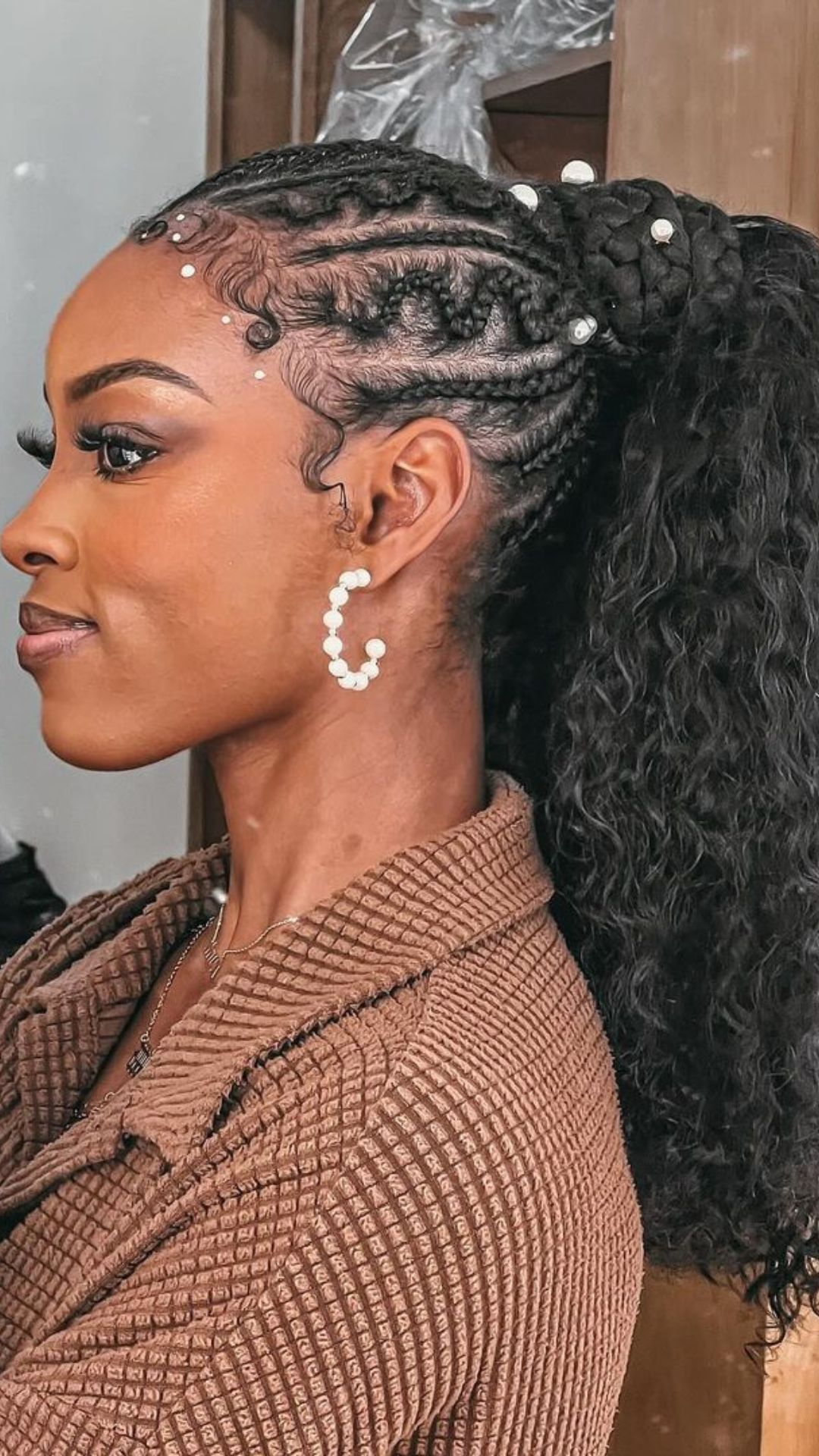 A woman with black voluminous braided ponytail.