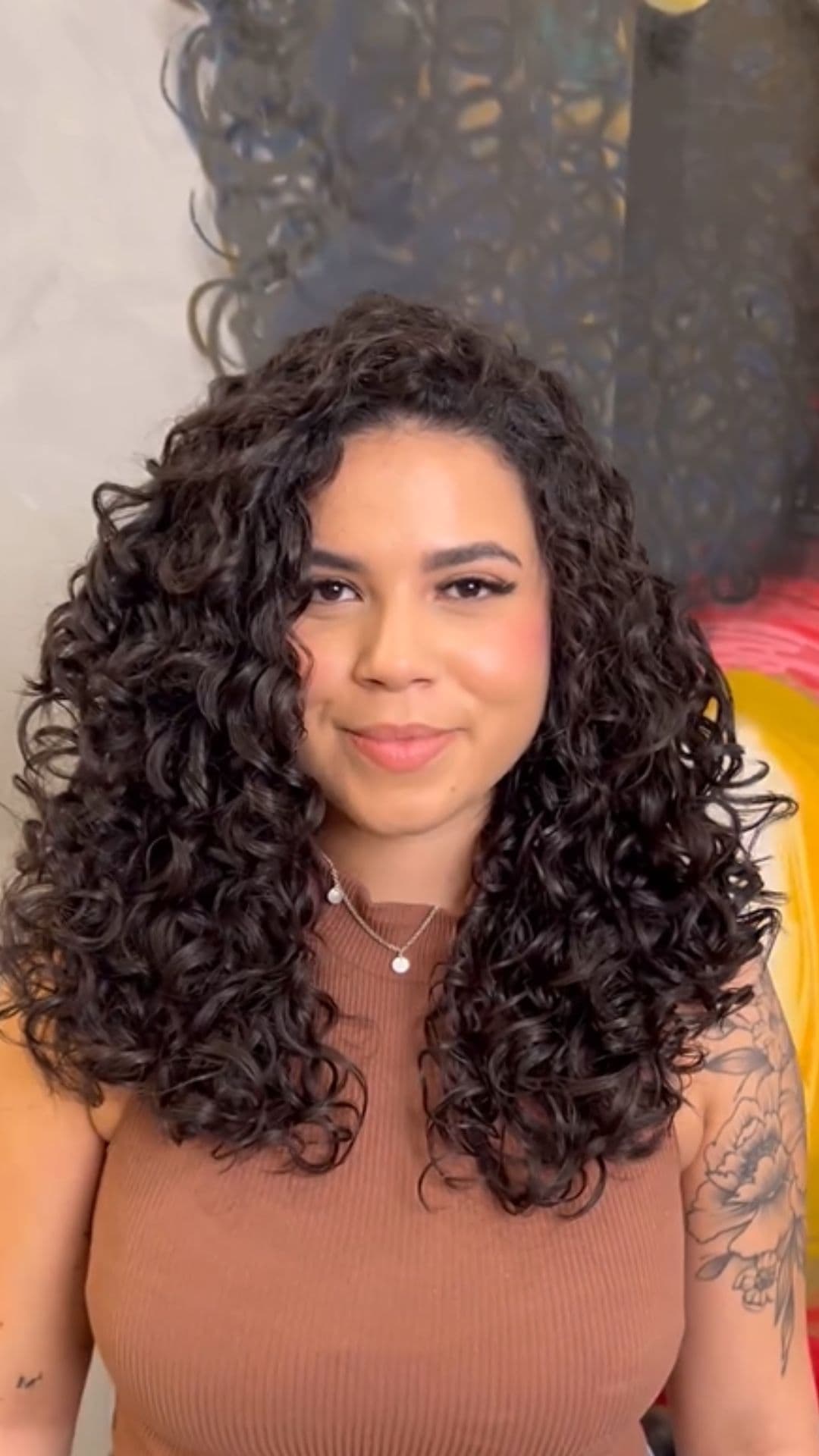 A woman modelling a curly hairstyle for medium-length hair.