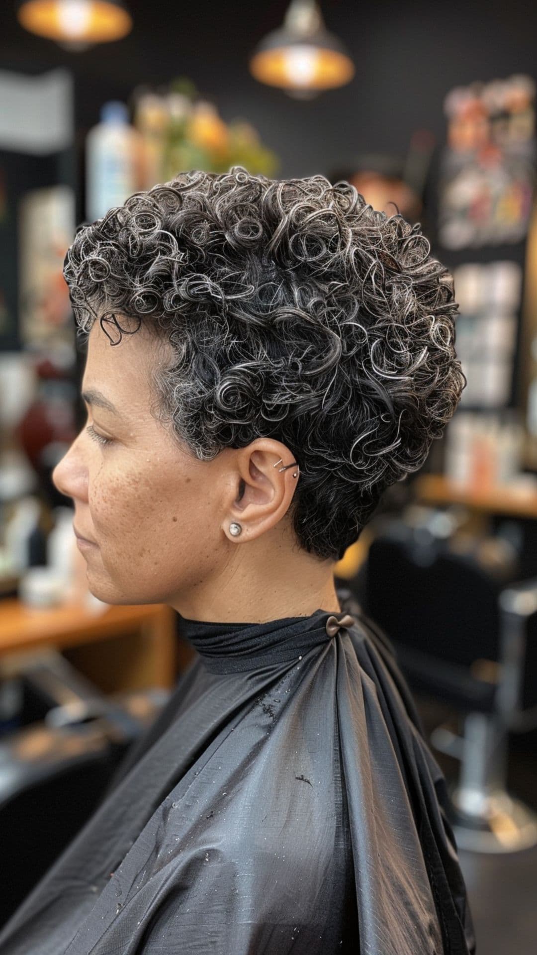 An older woman modelling a curly pixie cut.
