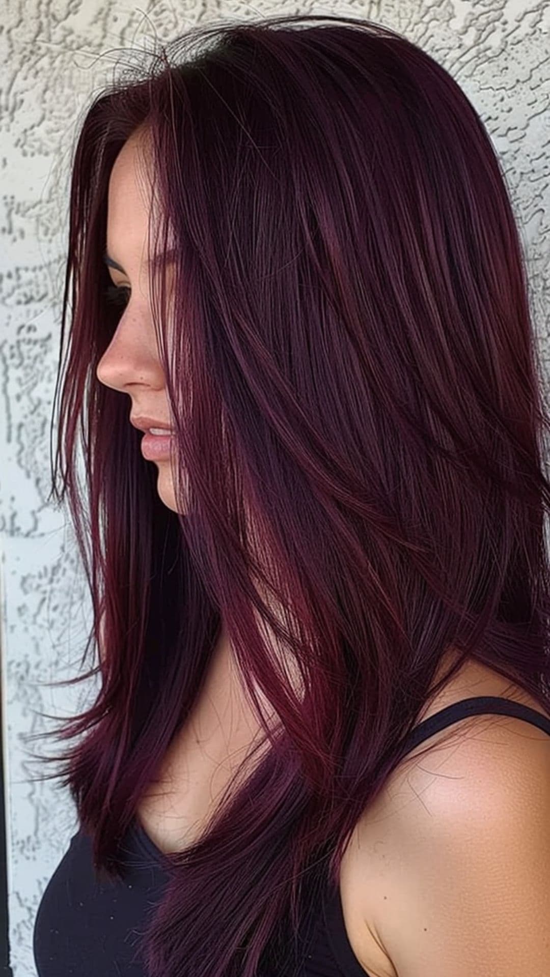 A woman modelling a deep and dark red violet hair.