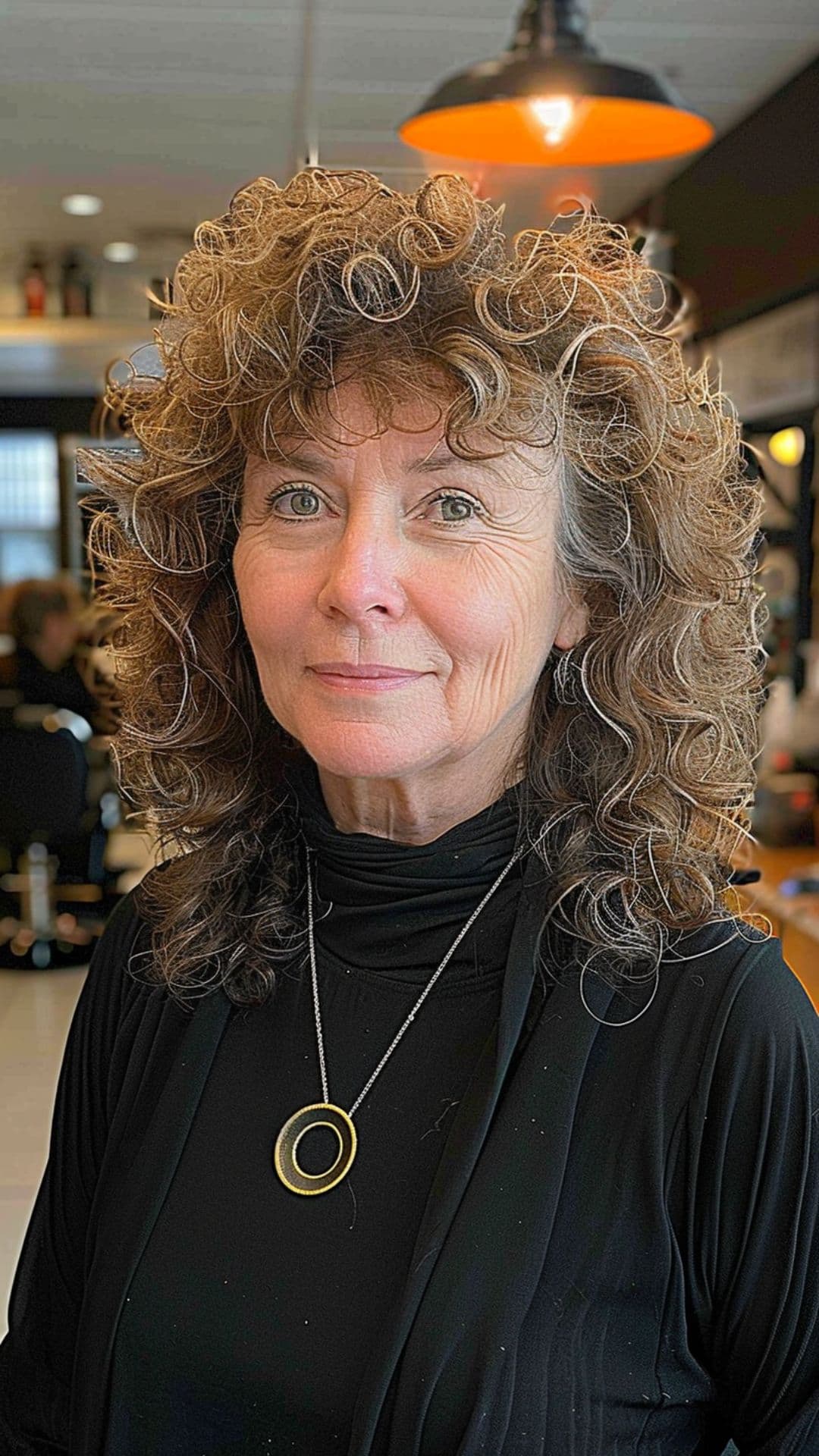 An older woman modelling a fringe bangs with curly hair.