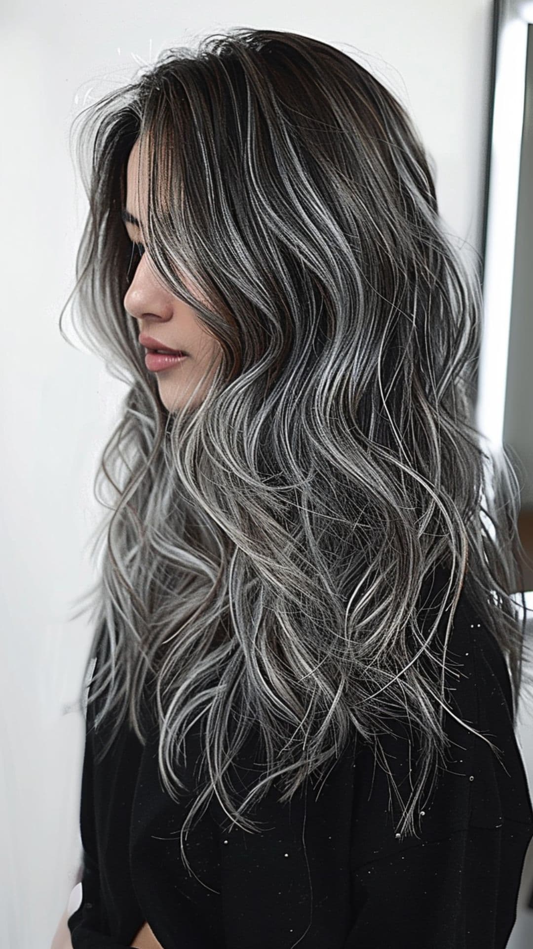 A woman modelling a gray silver balayage hair.