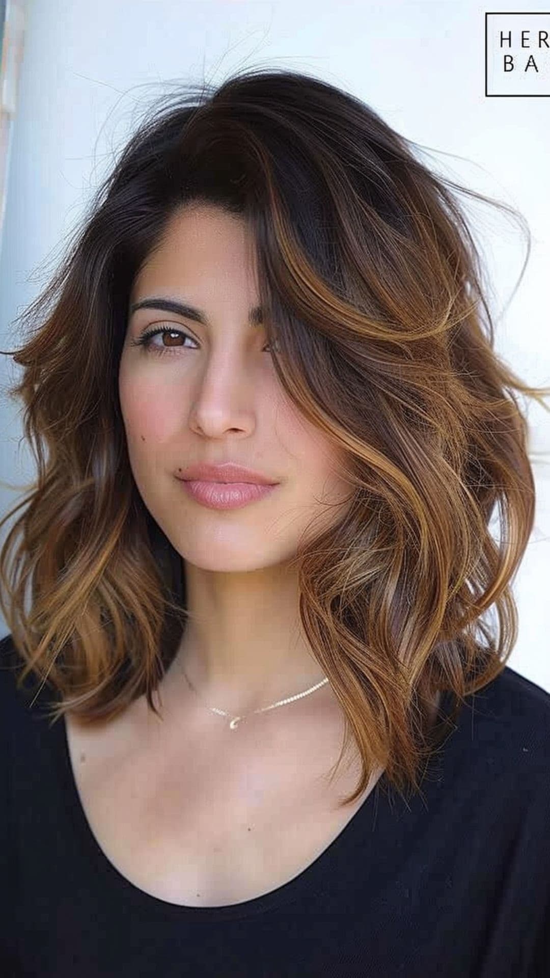 A woman modelling a layered medium-length hair with side part.