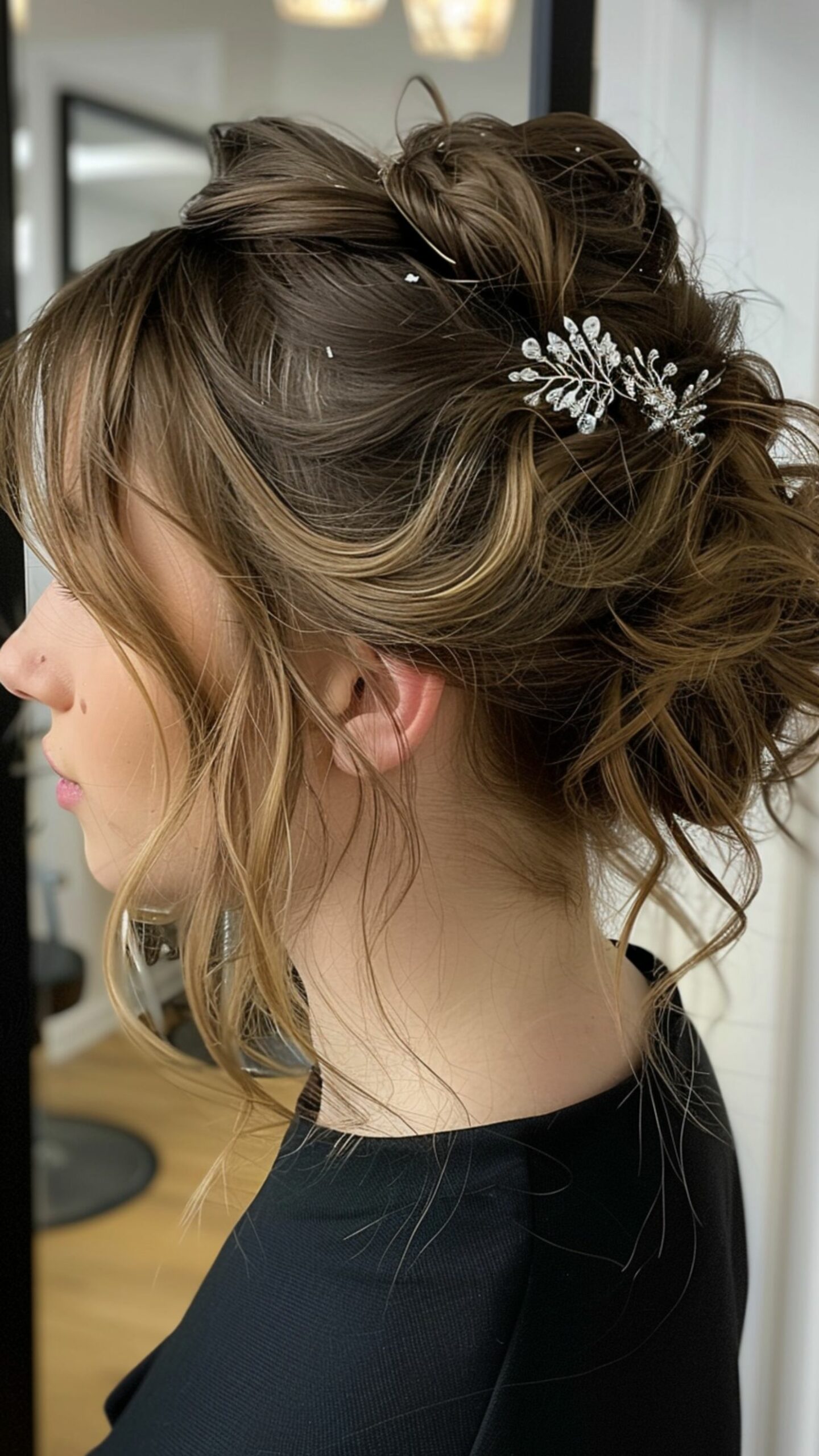 A woman modelling a messy bun wih a hair accessory and face-framing strands hairstyle.