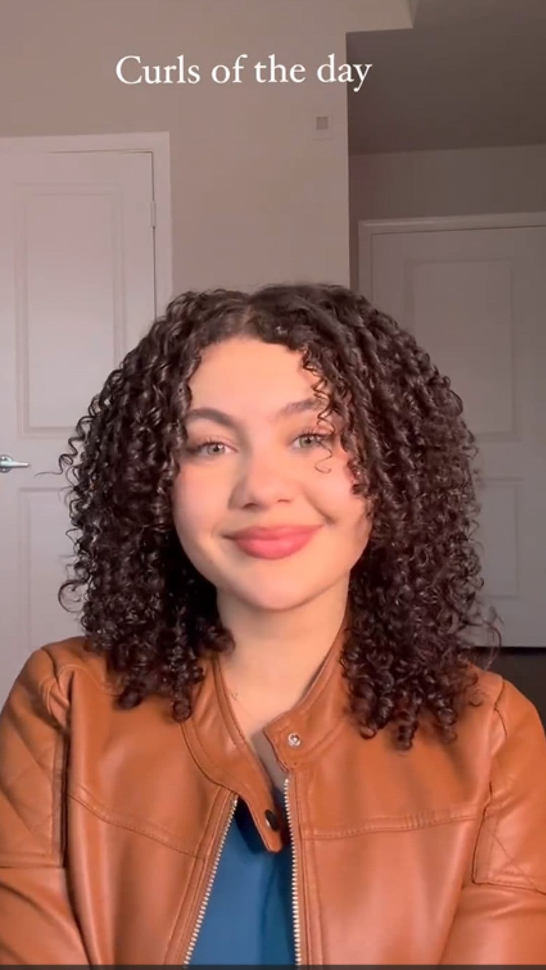 A woman modelling a middle part curls hairstyle.