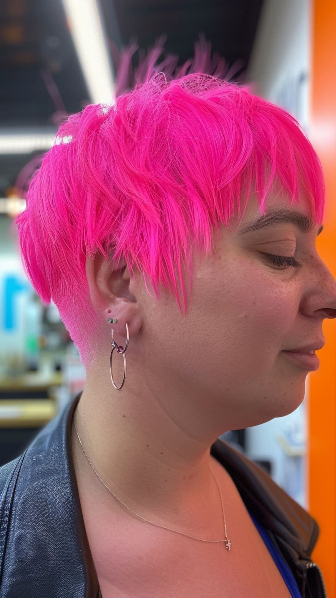 A woman modelling a neon pink pixie cut.