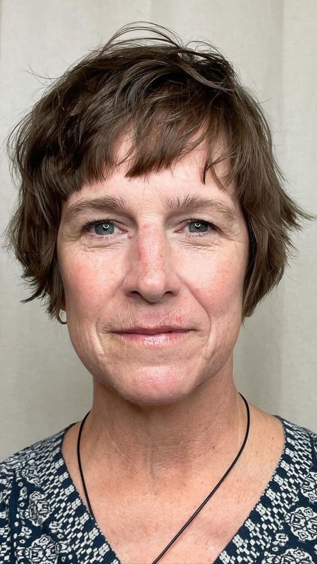 An older woman modelling a short shaggy wispy cut with fringe hairstyle.
