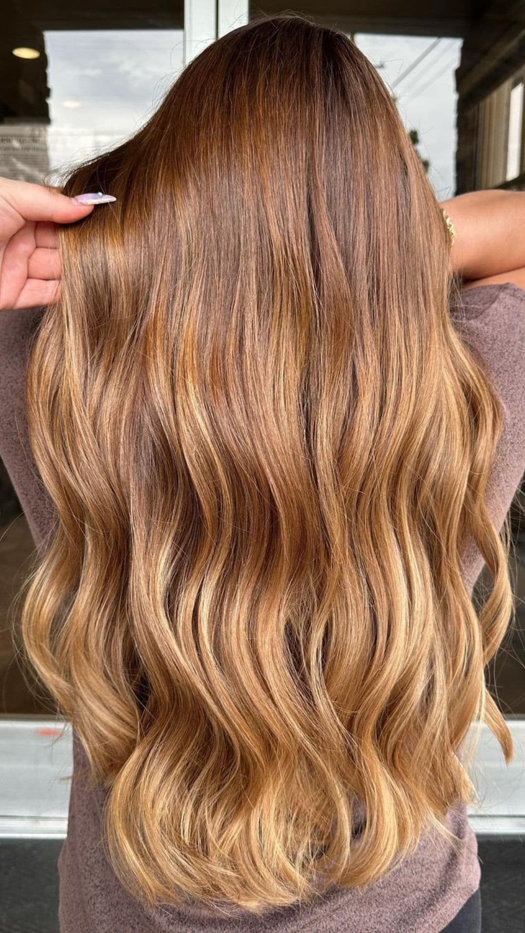A woman modelling a toffee to honey ombre hair.