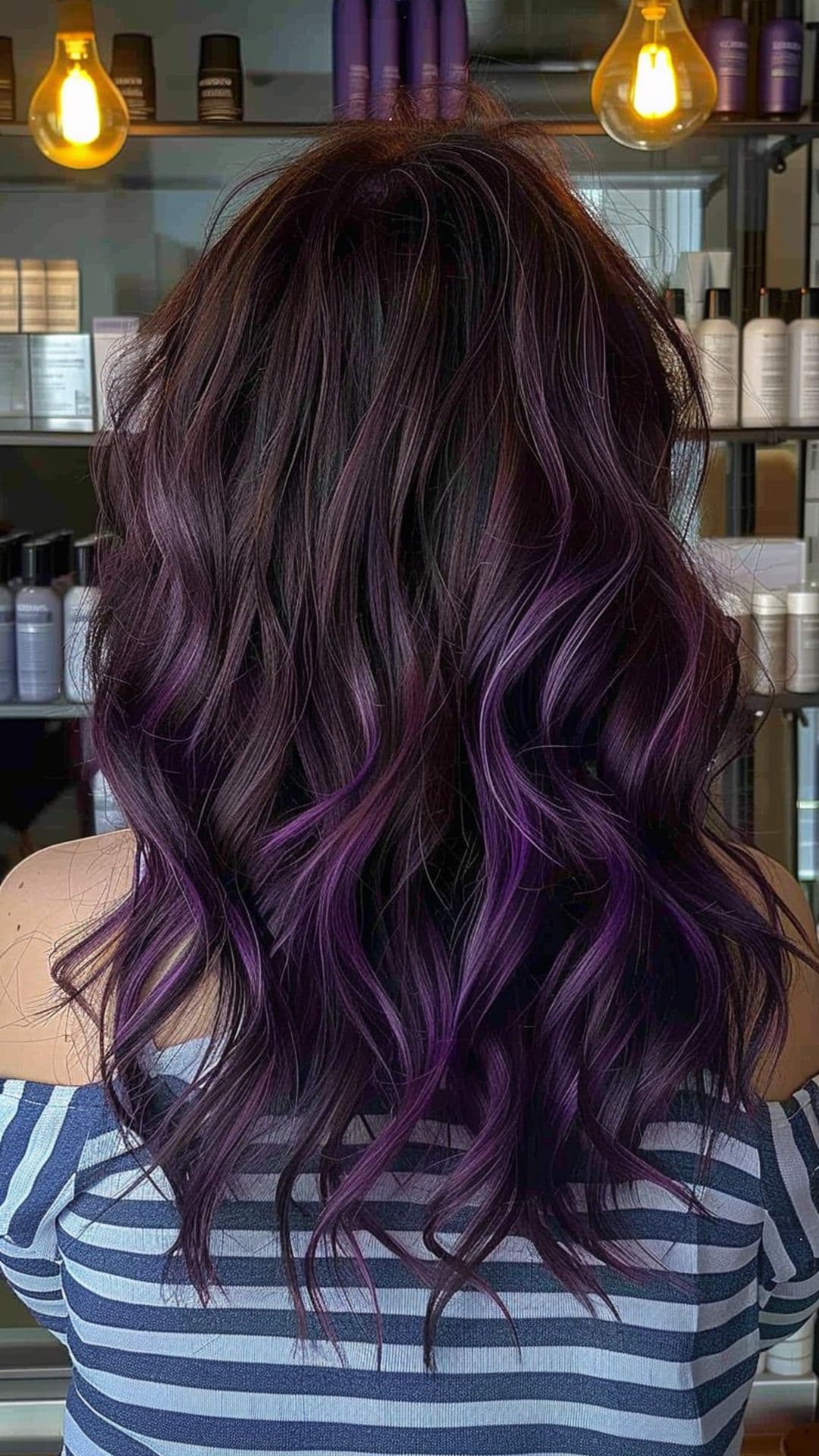 A woman modelling a violet balayage for black hair.