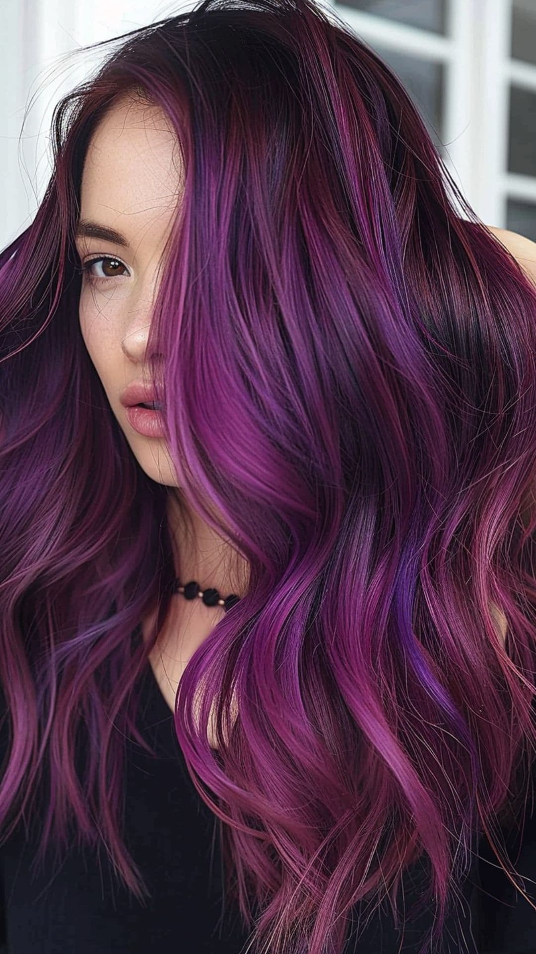 A woman modelling a warm toned purple hair.
