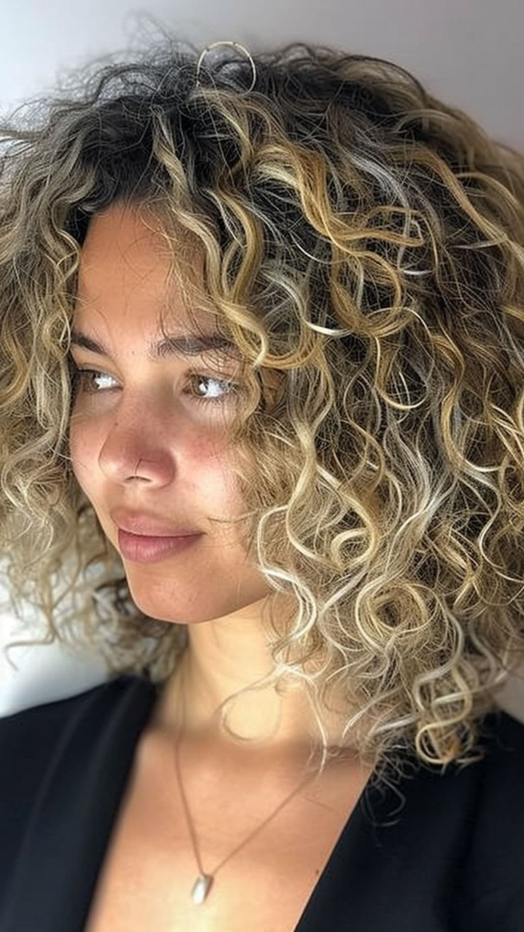 A woman modelling a blonde ombre curly hair.